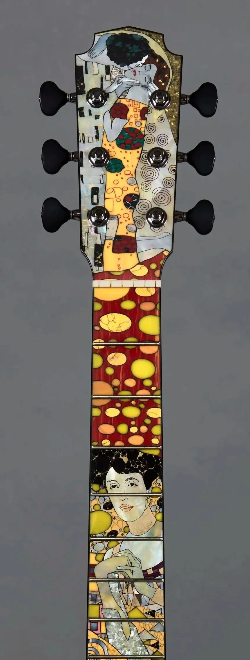 Decorative Grit Laskin guitar headstock with artwork inspired by Kandinsky and Klimt, featuring abstract figures and colourful patterns.