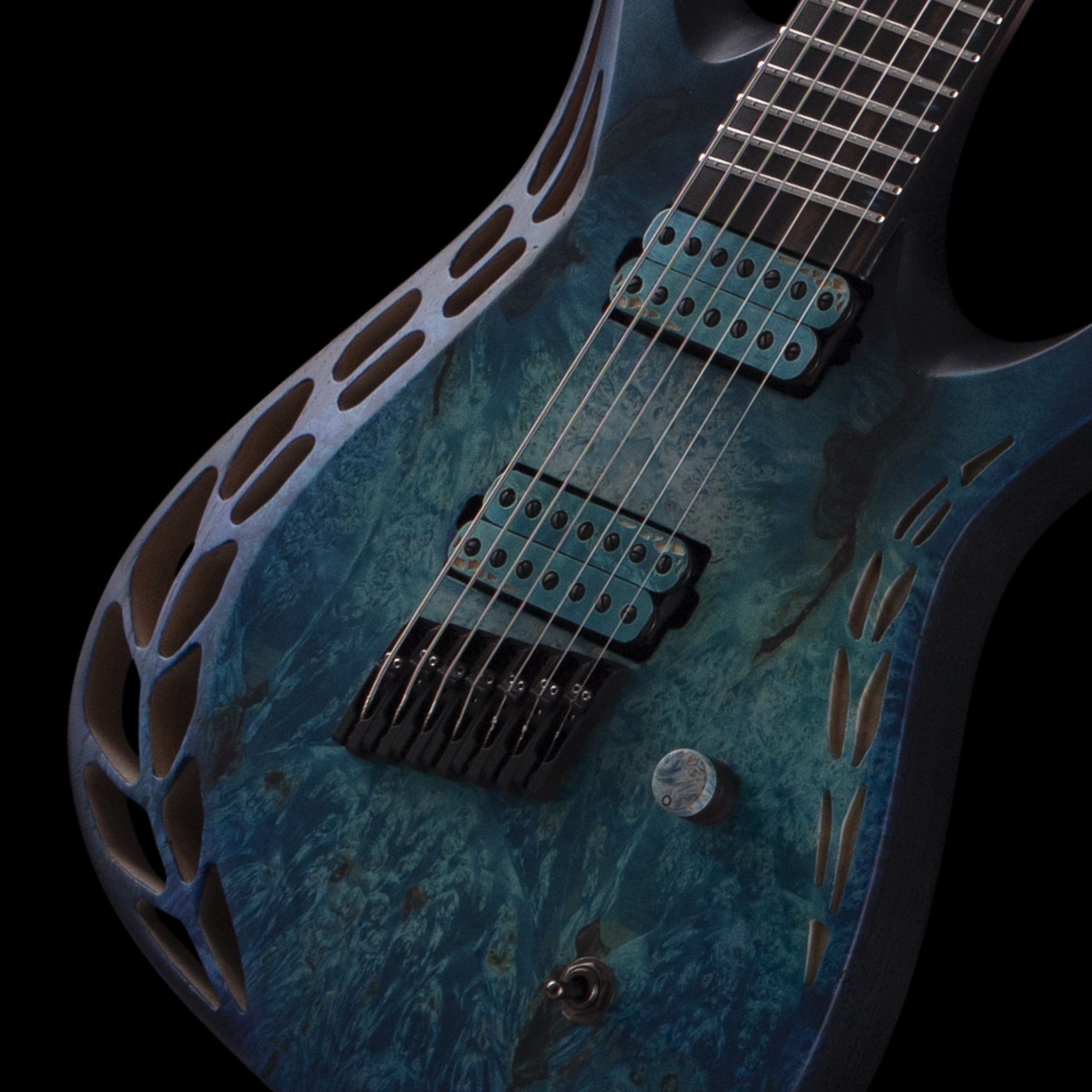 Close-up of an electric OD guitar's body, strings, and pickups on a blue textured surface, with part of the guitar fretboard visible.