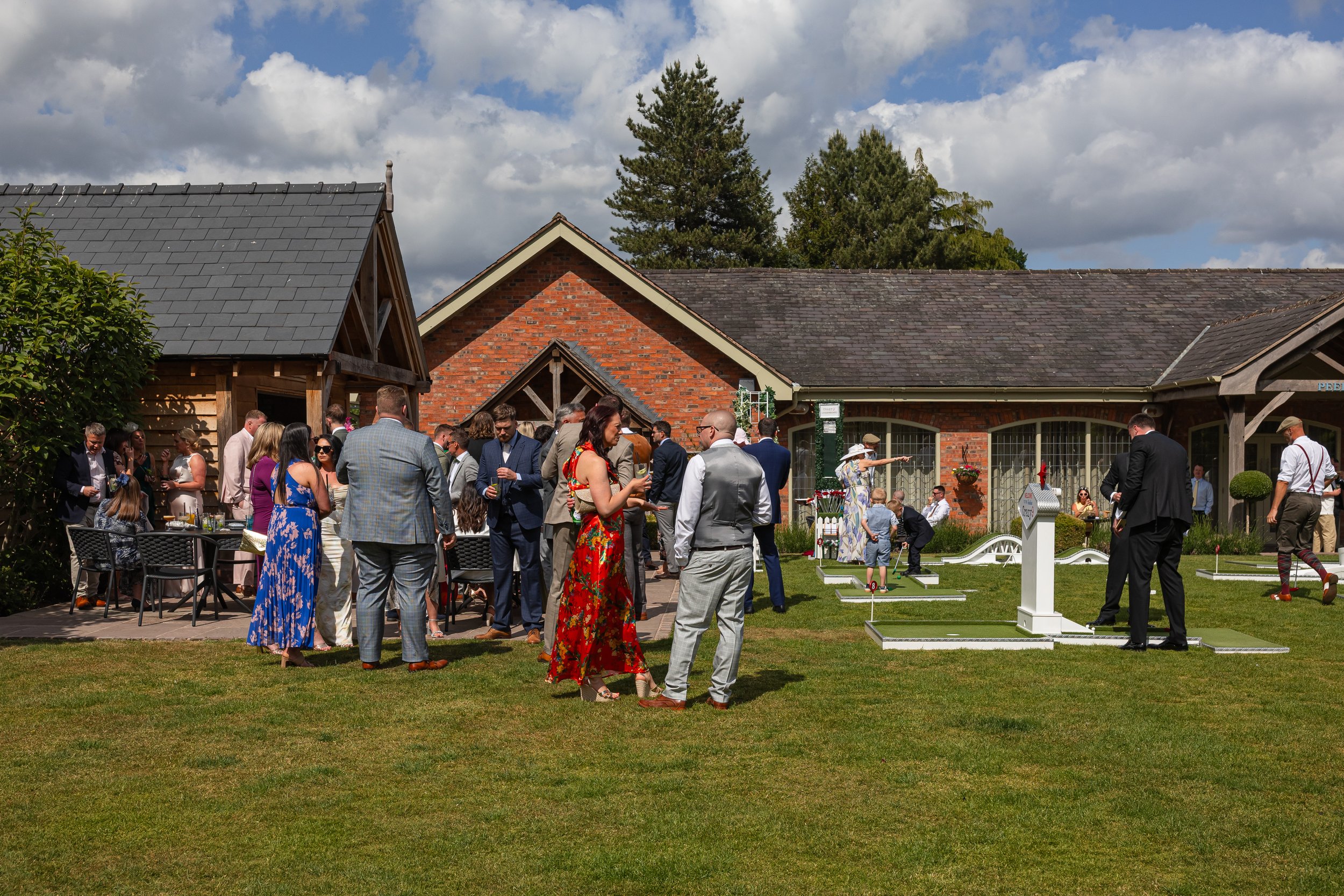 Guests mingling on the lawn during drinks reception at Colshaw Hall wedding venue in Cheshire
