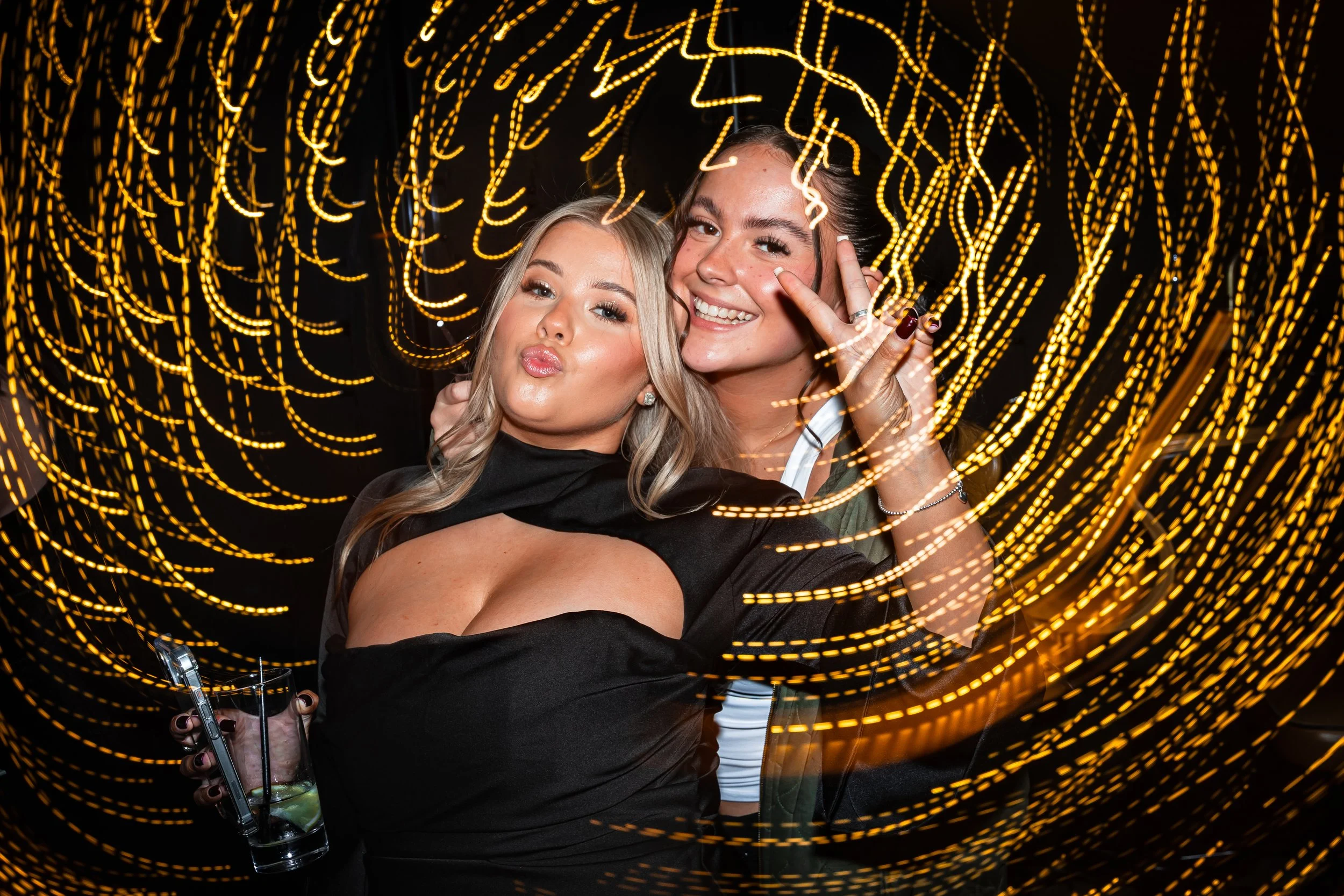 Fun candid party photo of guests posing at a birthday celebration in Cheshire with colourful light trails.