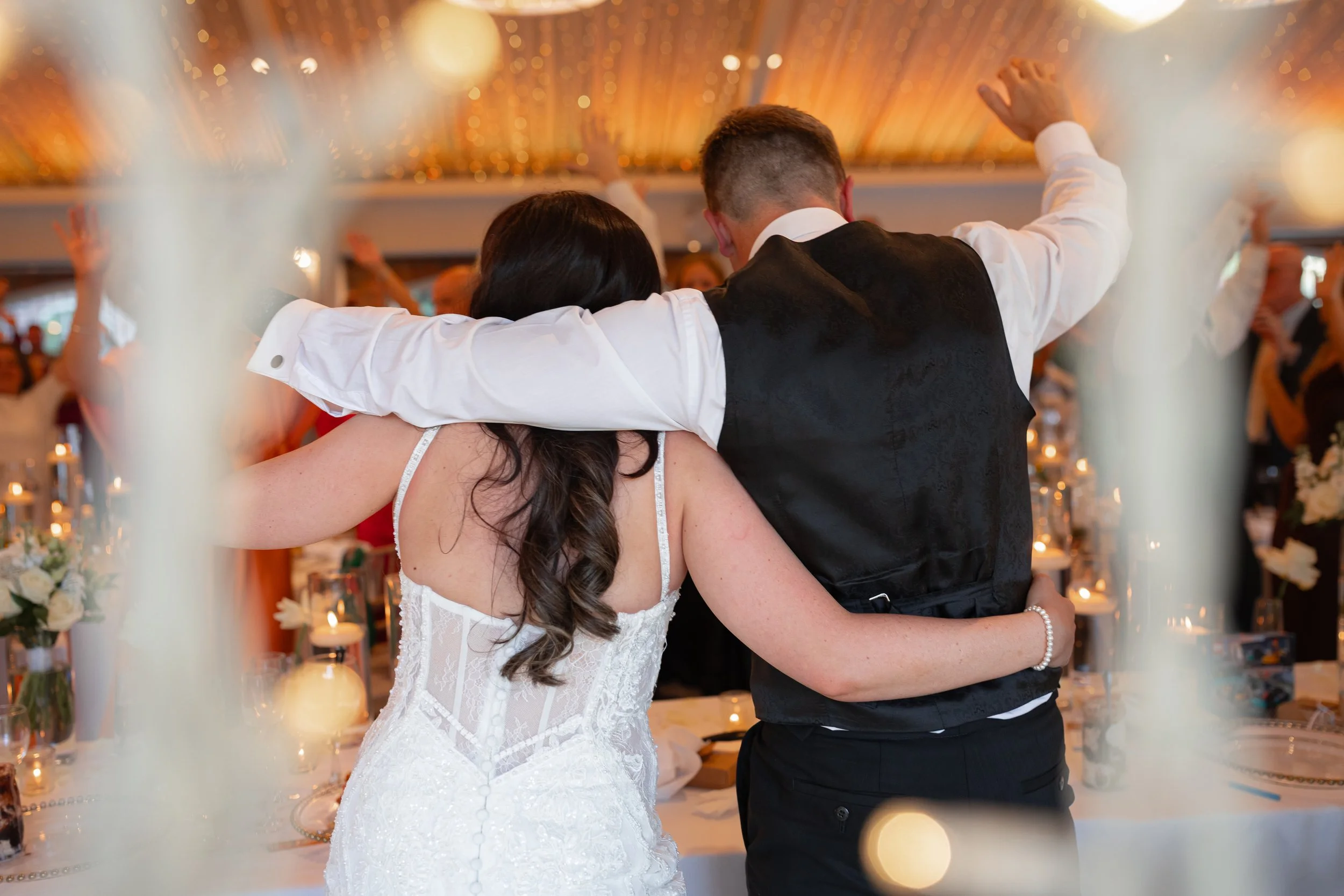 Bride and groom walking away together after the wedding speeches during their evening reception