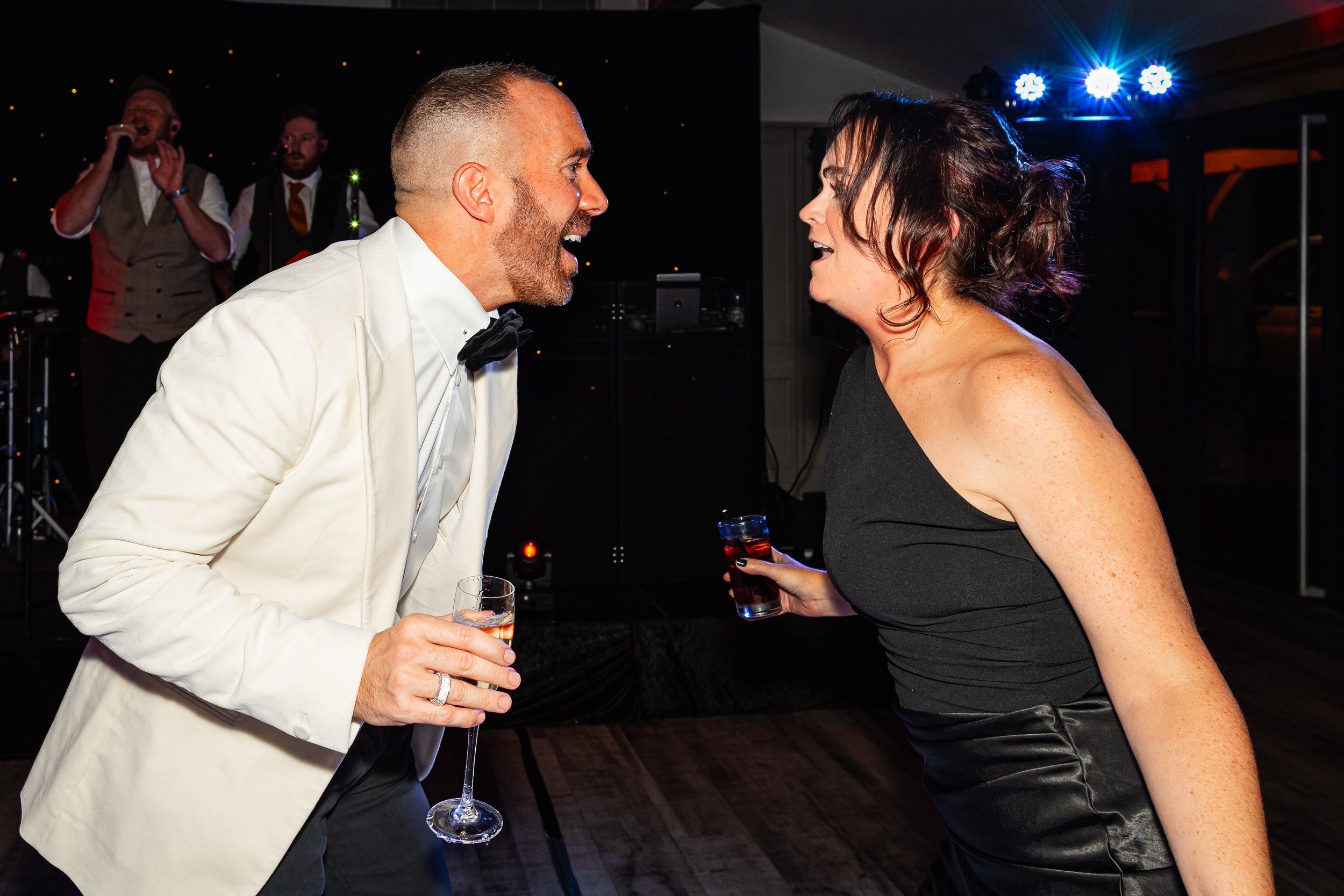 Candid party photo of guests laughing together on the dance floor at a Cheshire birthday celebration.
