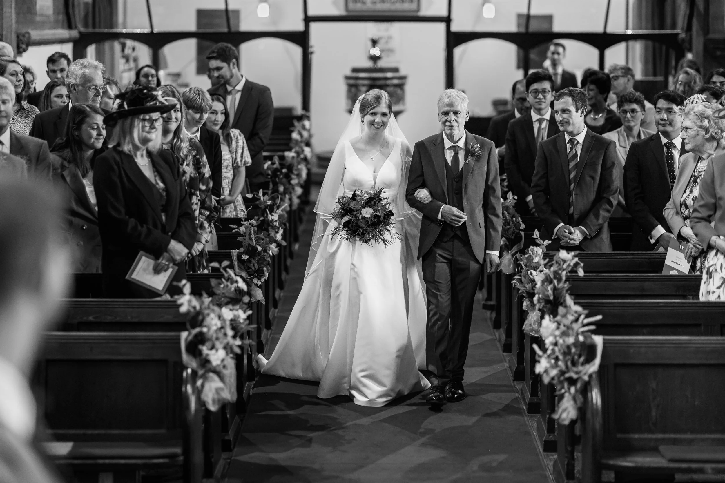 Bride walking down the aisle with her father during a church wedding ceremony in Knutsford, Cheshire.