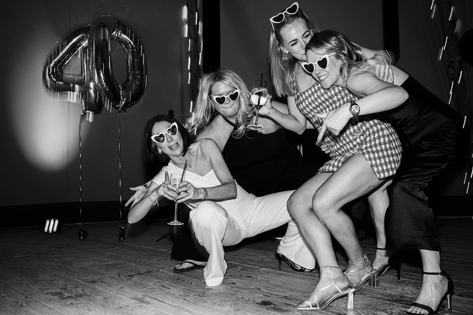 Guests posing and laughing at a 40th birthday party at Rylands Farmhouse Wilmslow, photographed by Cheshire event photographer Sasha Morgan