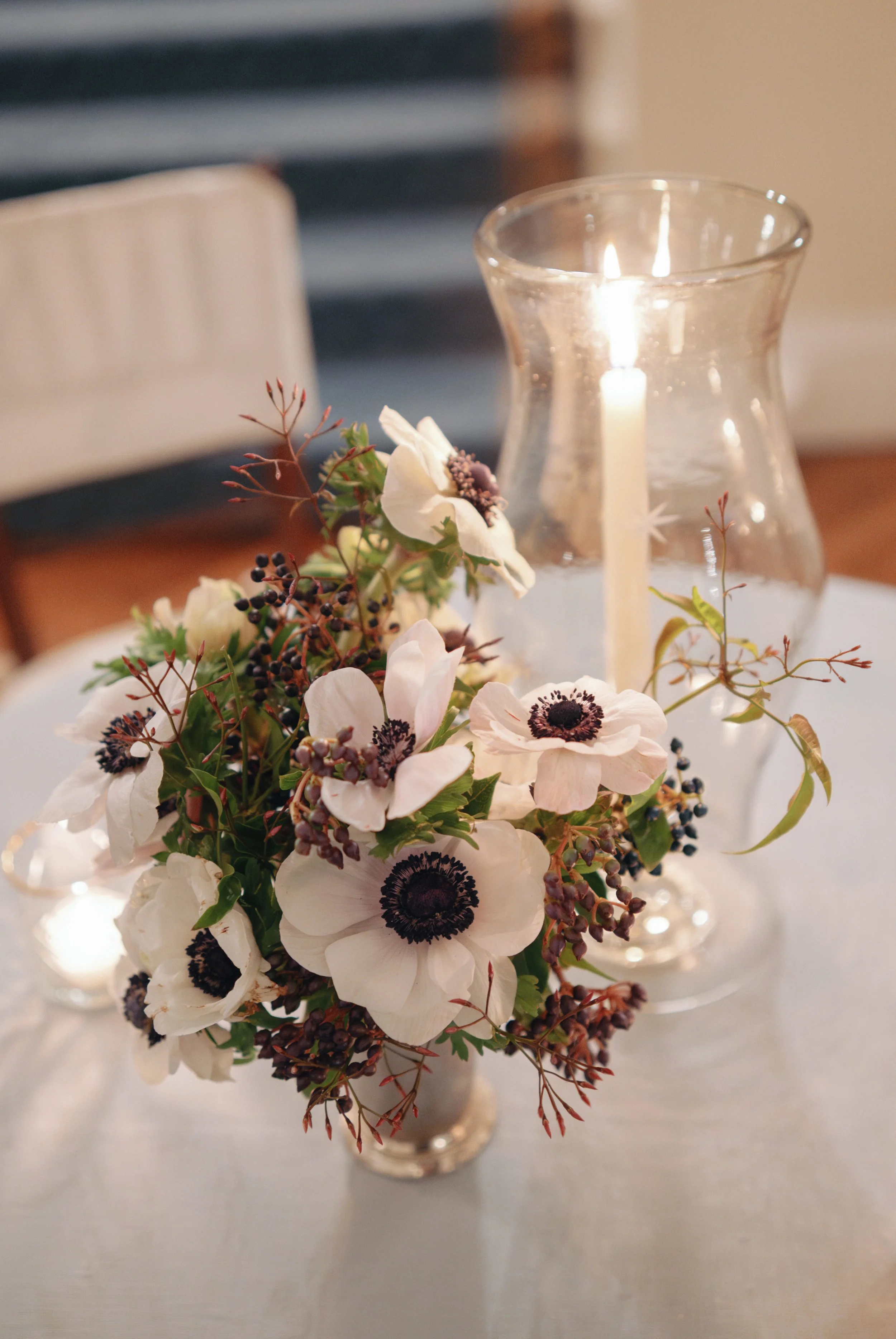 Star Etched Hurricane glass centerpiece with candles on dining table with flowers. 