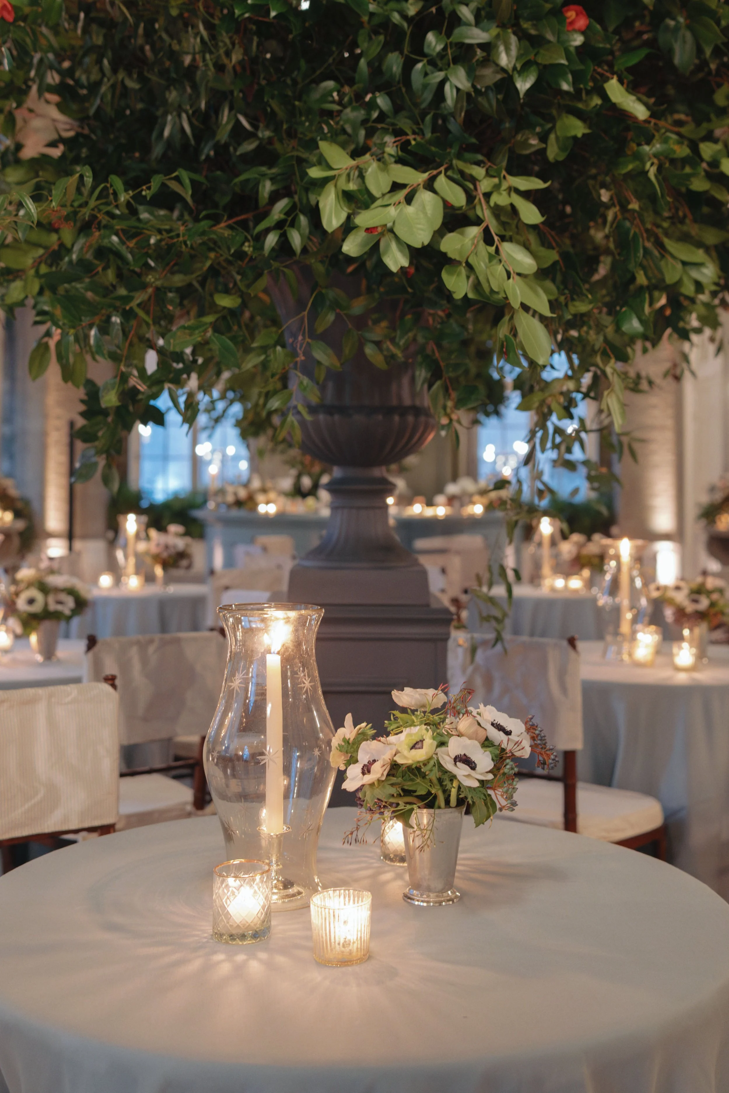 Hurricane glass centerpiece with candles on dining table