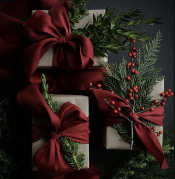 Bespoke luxury gifting with refined packaging, natural greenery, and sculptural ribbon—expressing brand identity through elevated presentation and material detail.