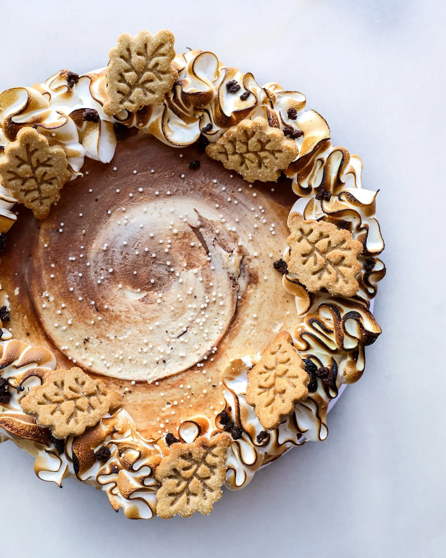October&rsquo;s Counter Cake is here! 🍂✨
Layers of bourbon vanilla cake with graham cracker buttercream, smoked chocolate ganache, chocolate crunchy bits, and the cutest little graham cookie leaves, topped with multiple swirls of toasted meringue.

