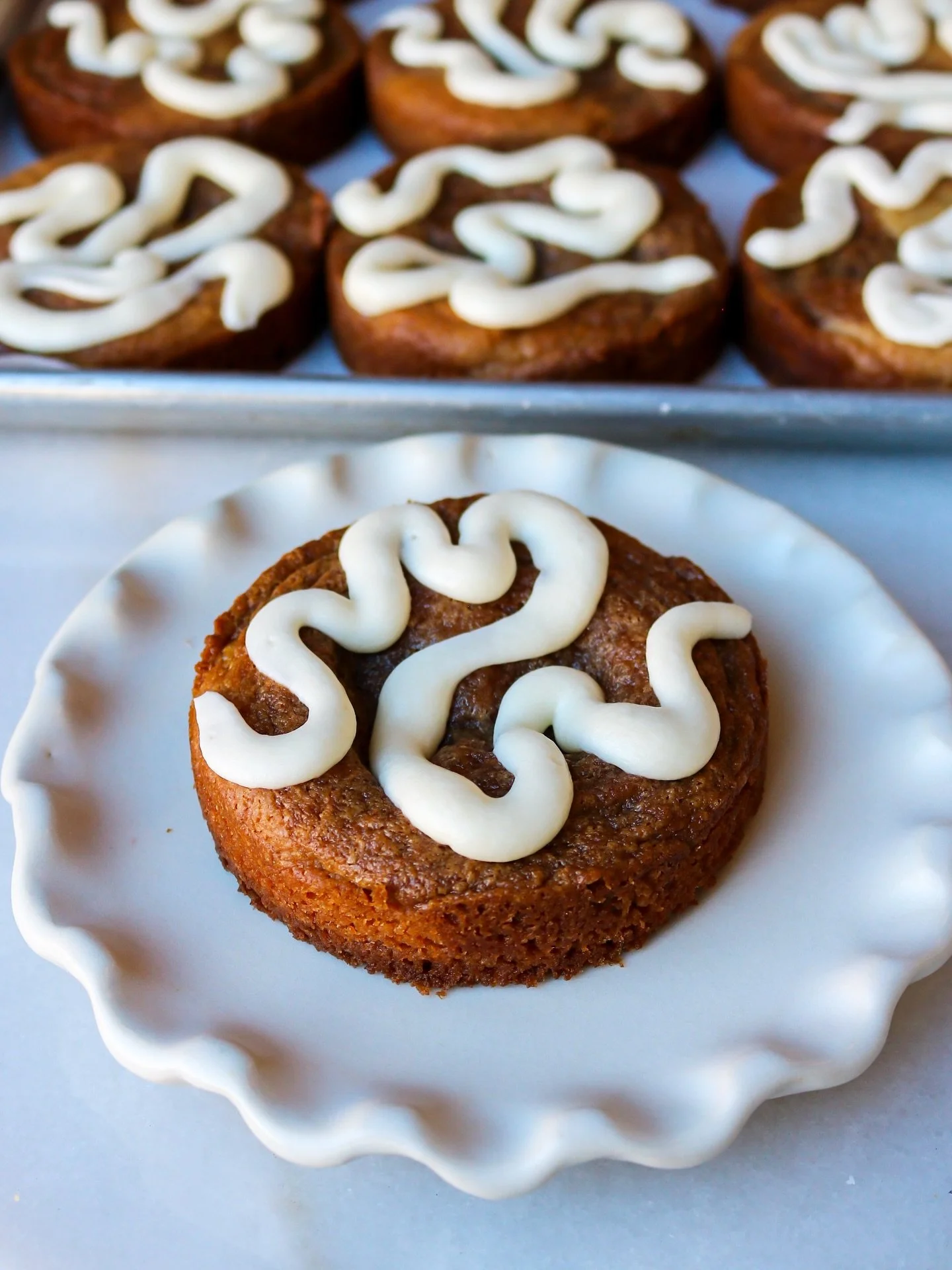 Swirls on swirls on swirls. 🤍✨ Our Cinnabun Cookie combines sourdough and brown sugar cinnamon cookie dough, finished with a tangy cream cheese frosting drizzle. Get it while you still can! #thegoodbatch