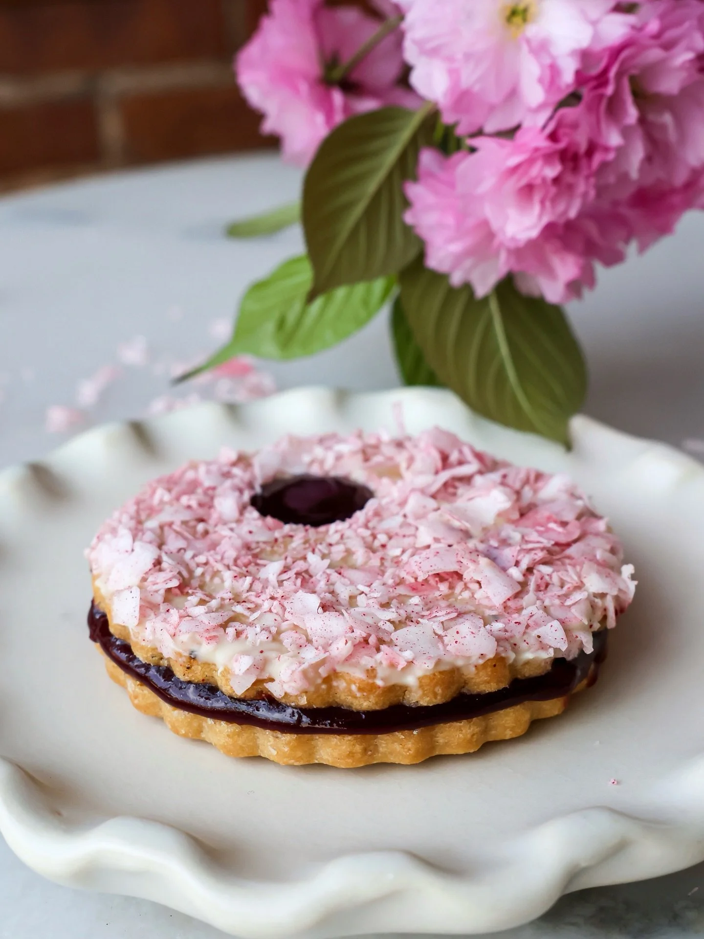 Spring has officially entered the chat. 🌸

Introducing our Cherry Blossom Cookie: cherryberry jam nestled between brown butter shortbread cookies and strawberry-tossed coconut. A spring blossom Linzer, if you will. Available now through mid-May, in-