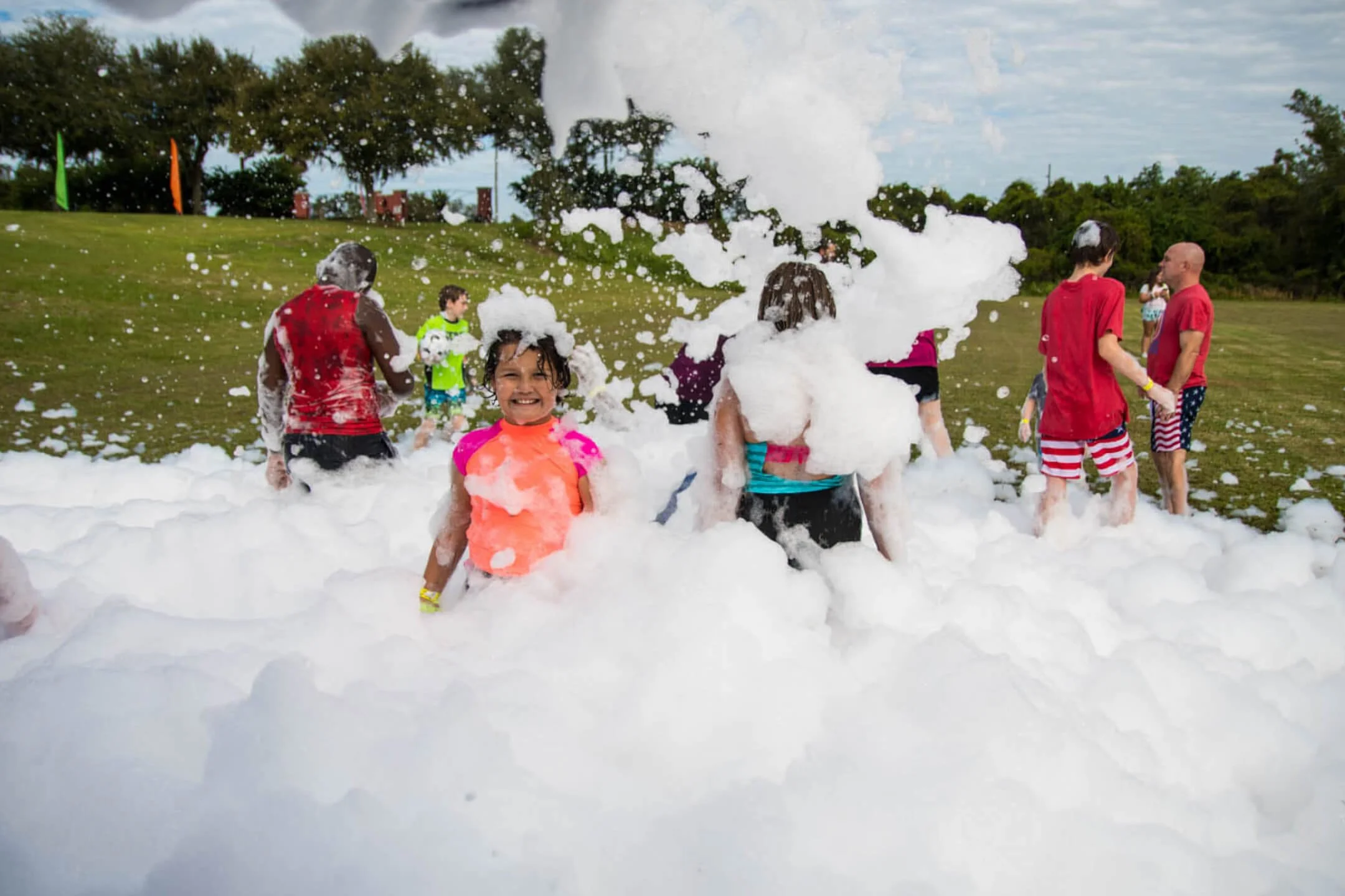 Kids having fun at a Varsity Foam foam party in Chicagoland playing in foam at an outdoor birthday or school event