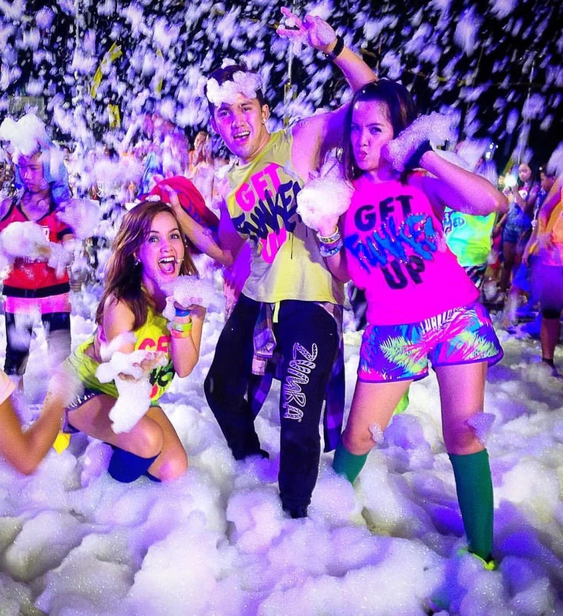 Teens dancing and celebrating at a Varsity Foam foam party in Chicagoland at an outdoor event wearing colorful outfits