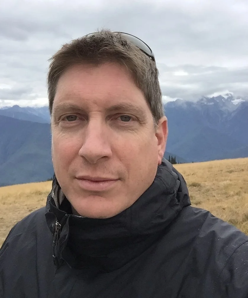 Portrait of Matthew Walker, photographer and collections consultant, outdoors in a mountain landscape.
