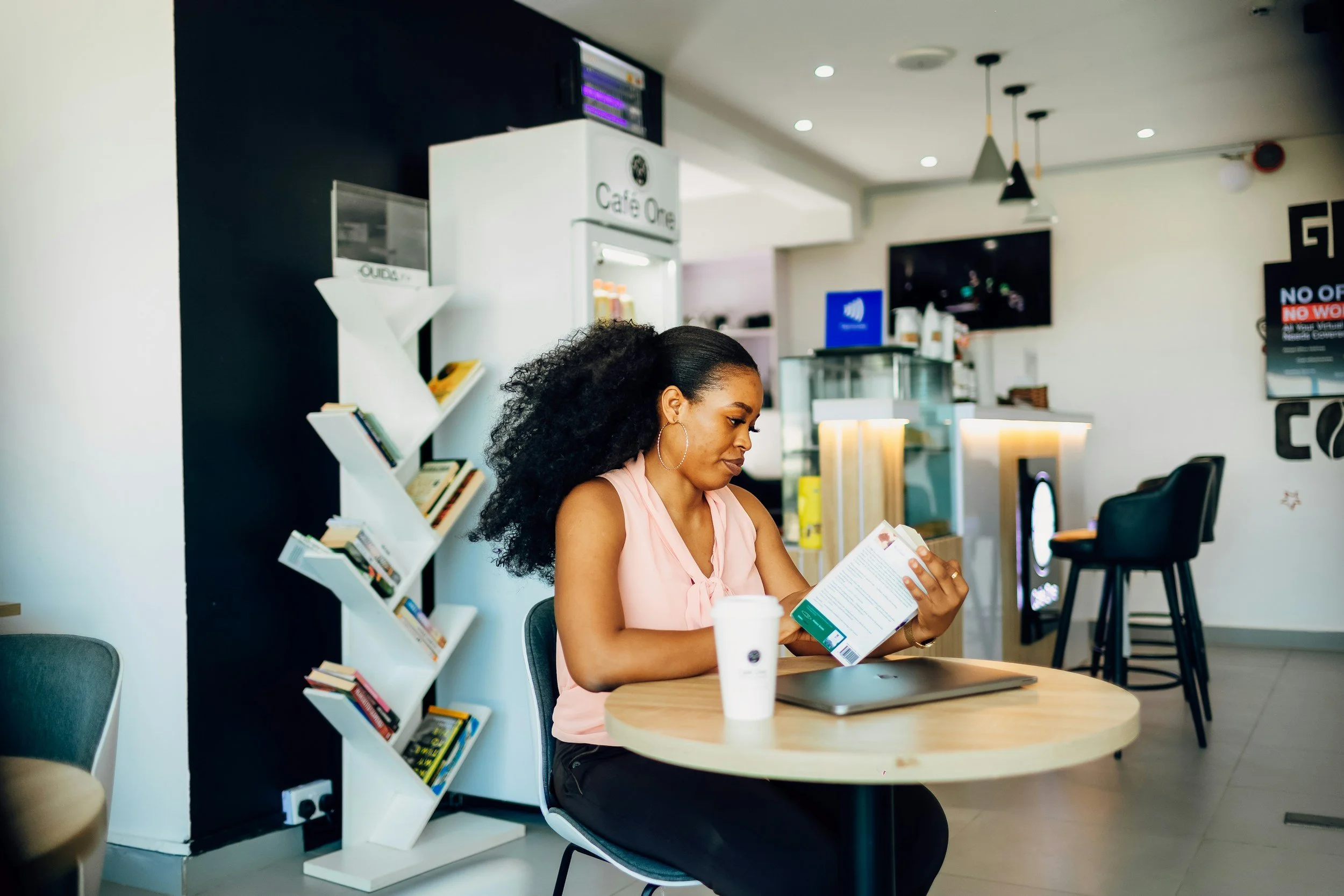 black woman sitting in coffee shop reading