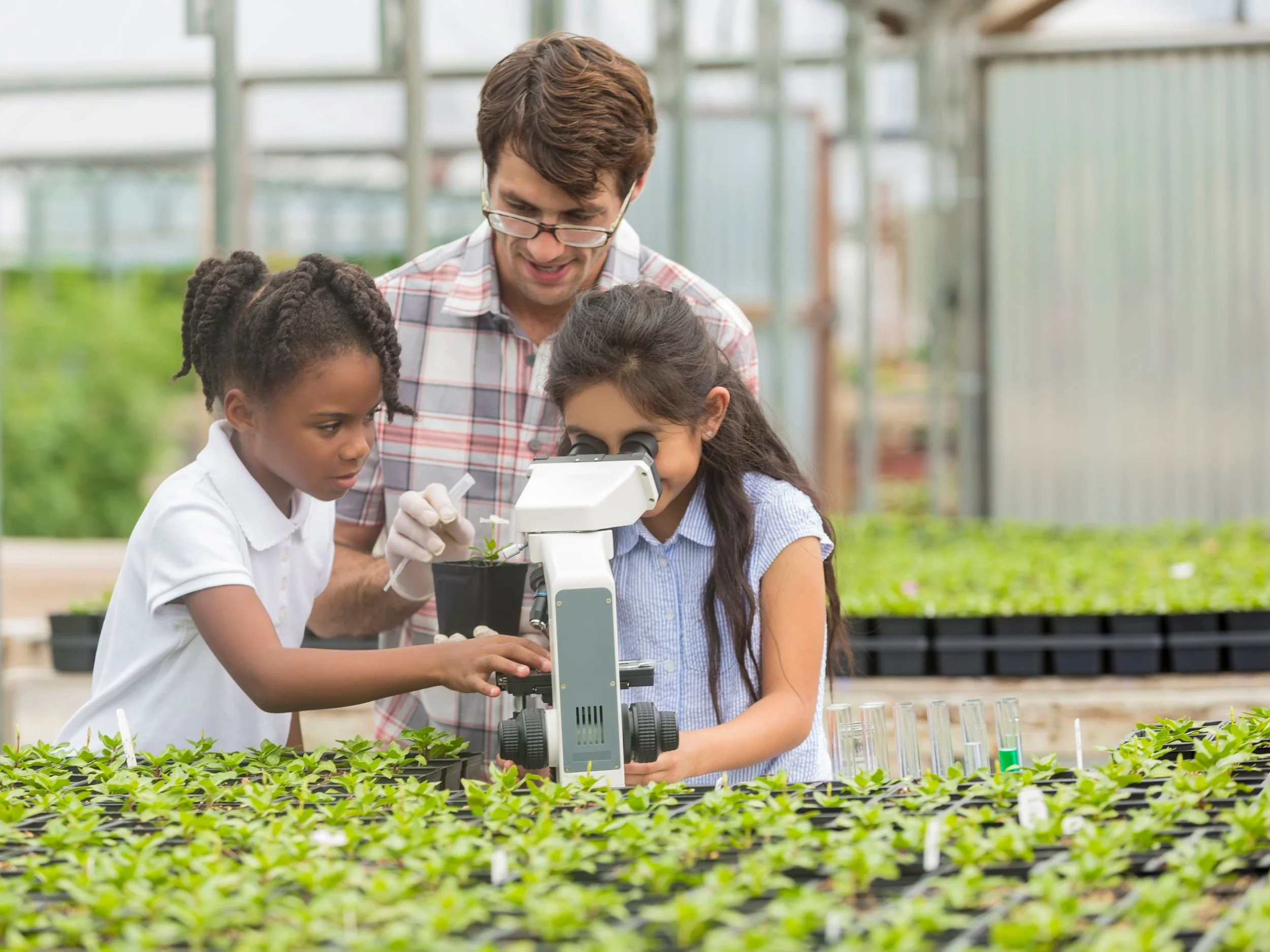 two young girls at plant nursery using a telescope