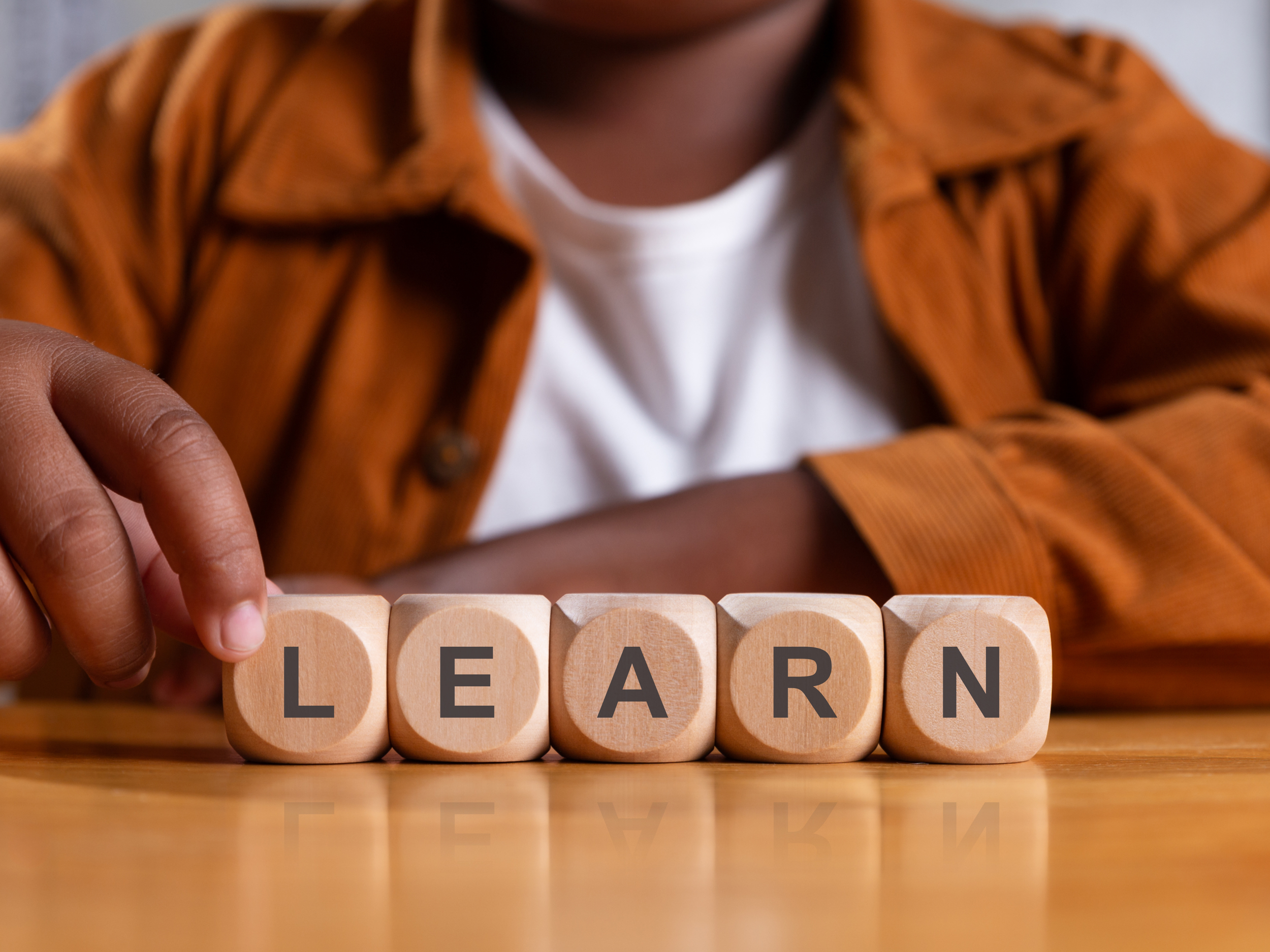closeup of blocks spelling the word learn held by black boy
