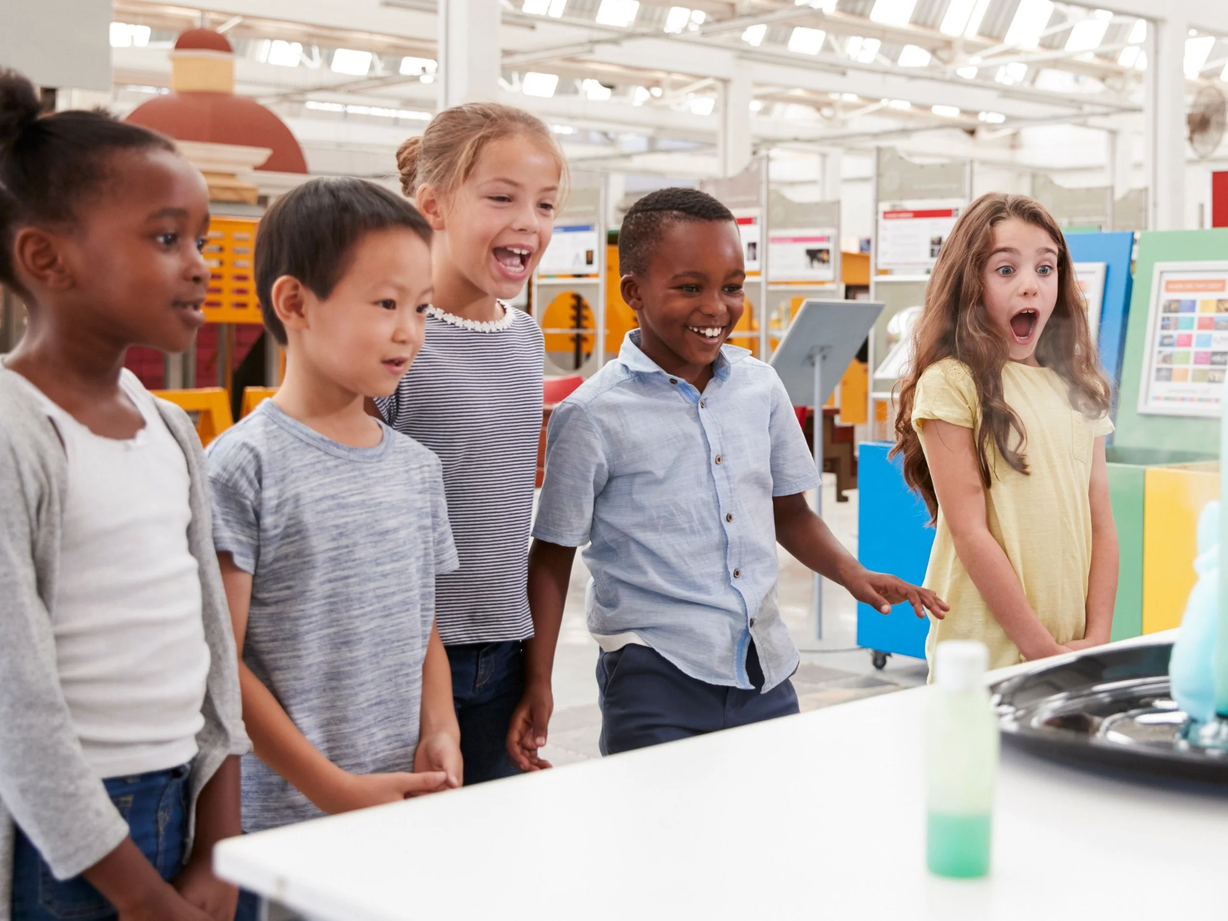 group  of kids joyfully startled at science demonstration