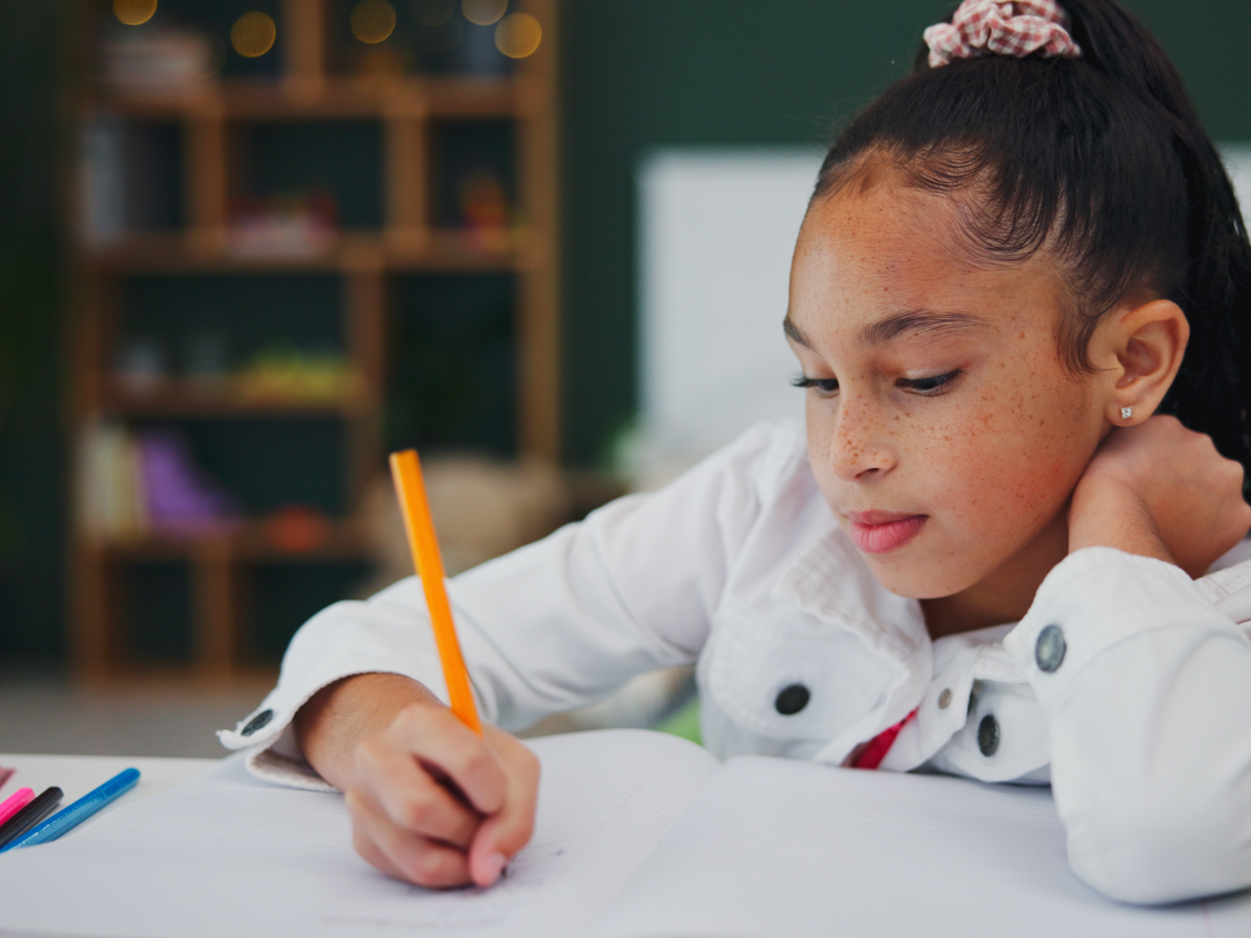 closeup of young black girl sitting at a table doing school work