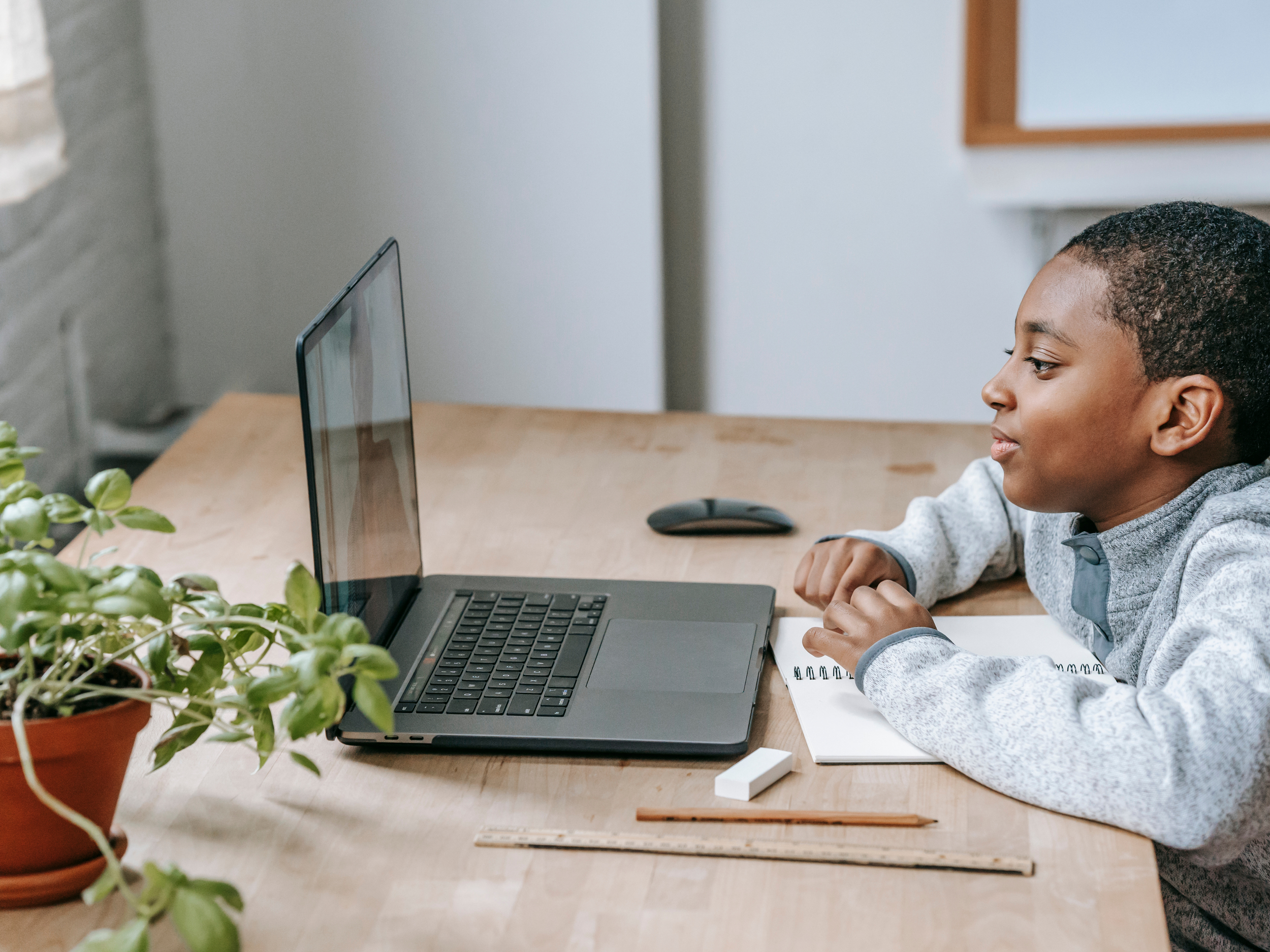 little black boy on laptop sitting at a table