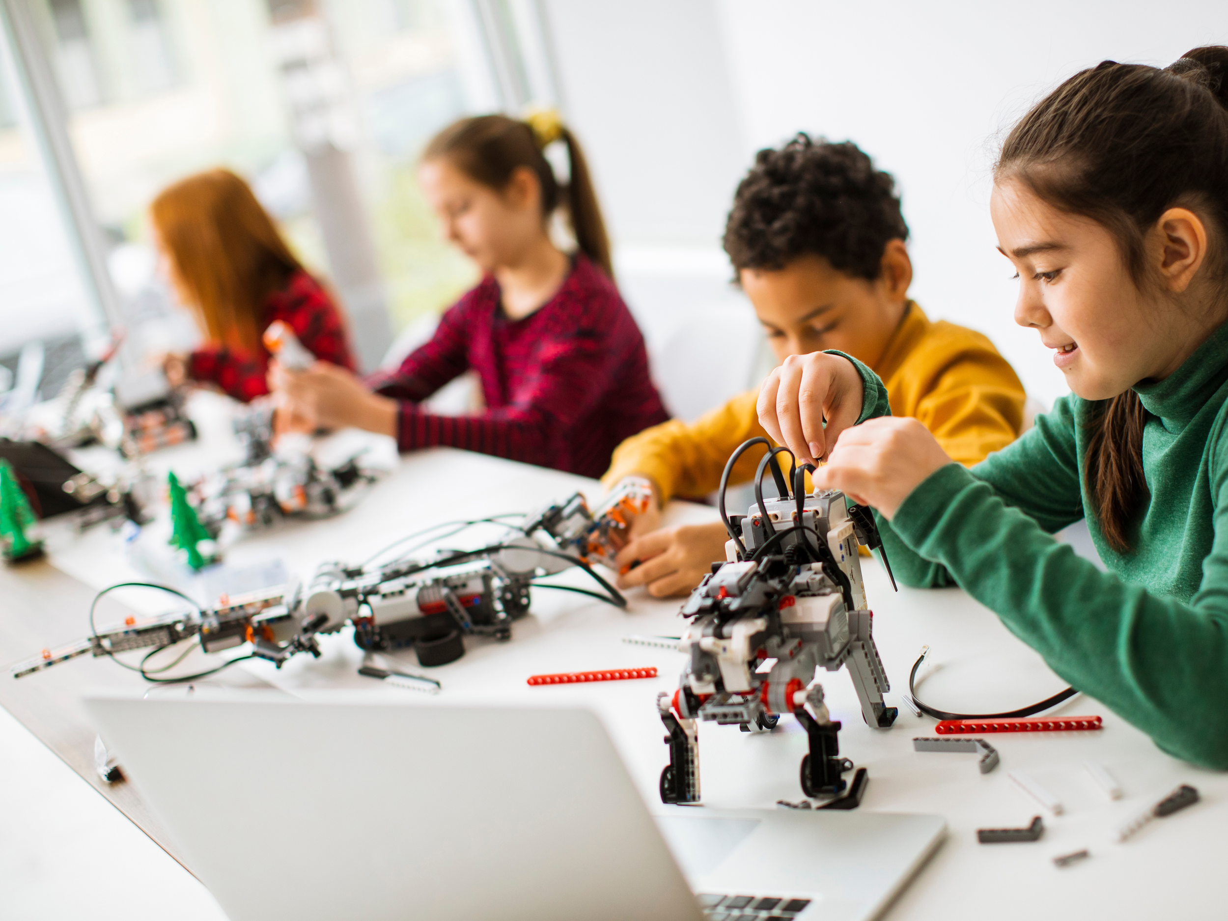 four kids at a table doing robotics project