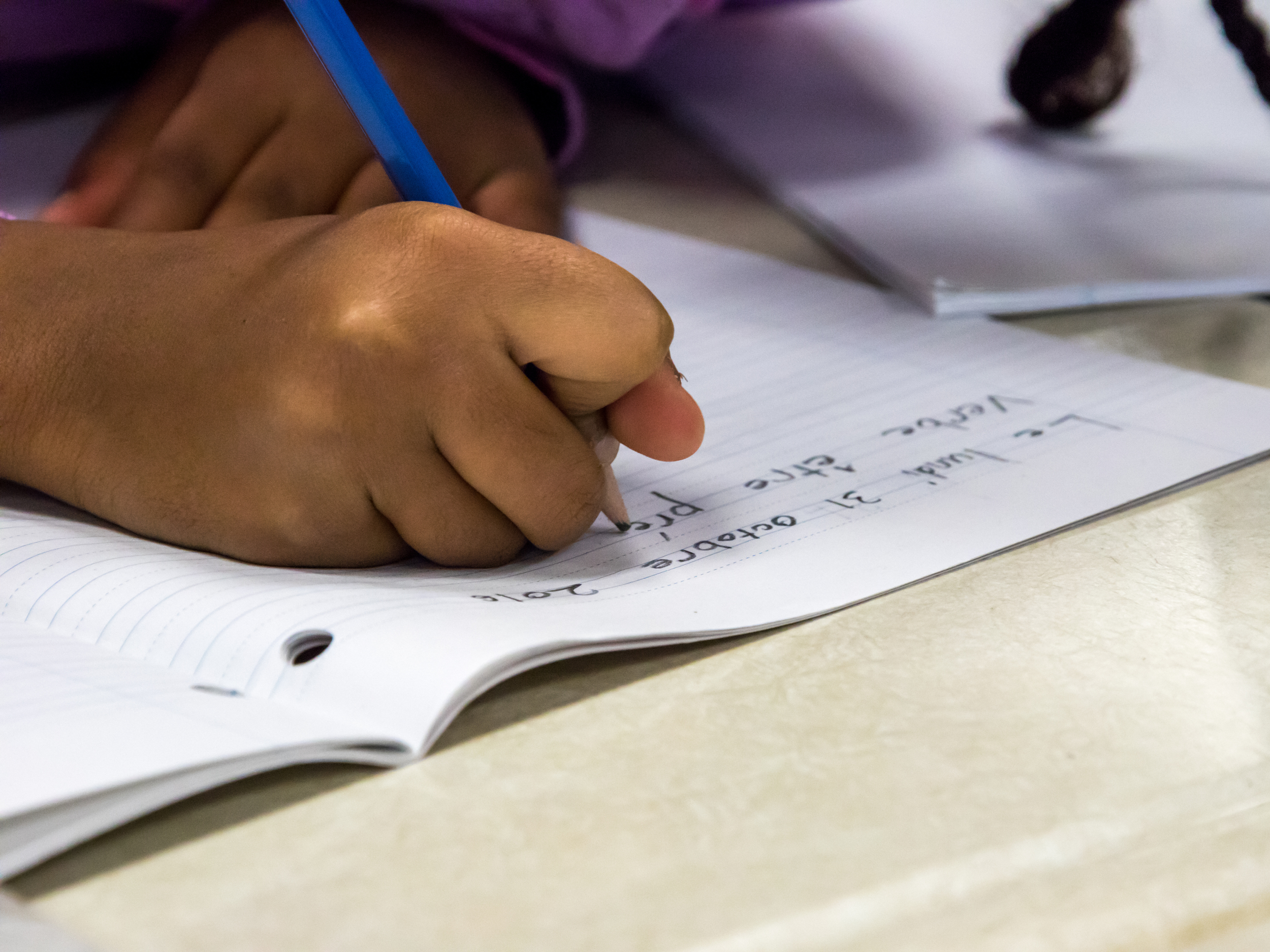 closeup of hand as black kid writes
