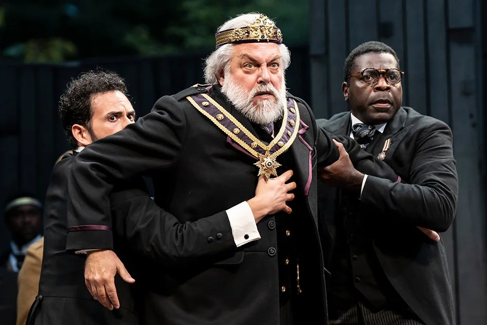 King Lear being held back by two gentleman