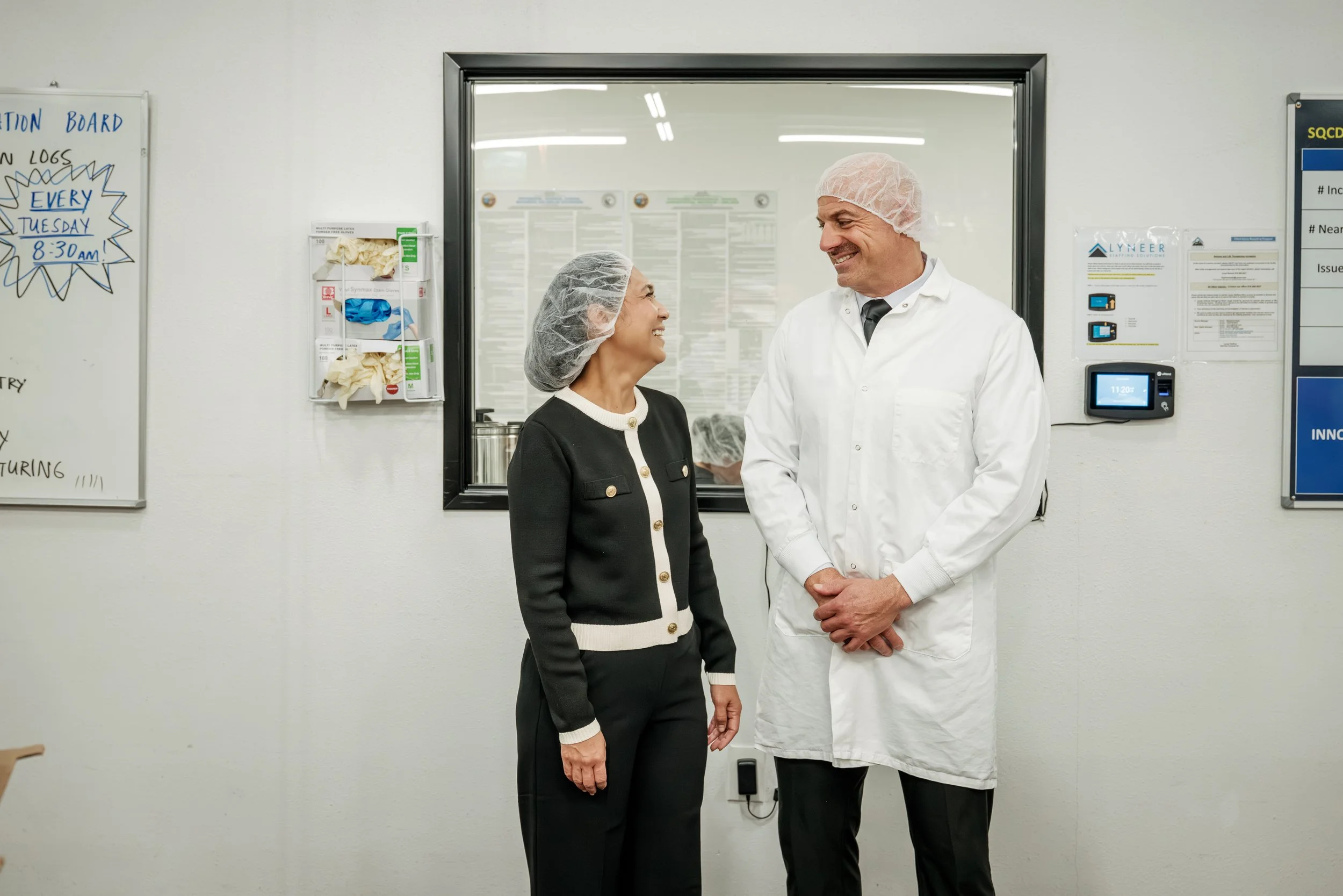 Fred Khoury, Chief Scientific Officer, and Kat Khoury, President, smiling together on the manufacturing floor of Above Rinaldi Labs.