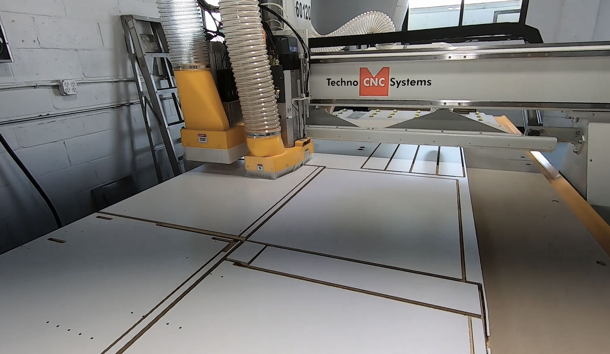 Industrial CNC router machine cutting wooden panels or sheets.