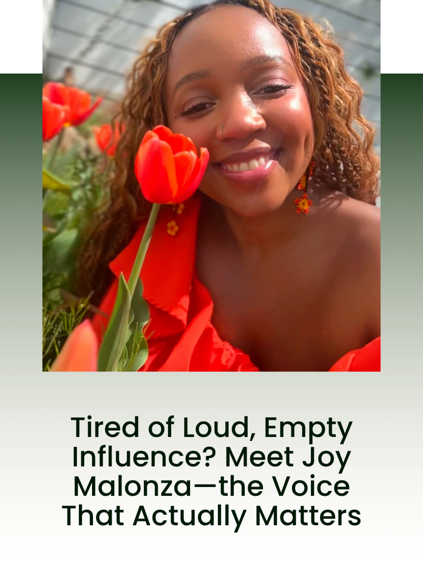 A woman with curly hair smiling and holding a red tulip close to her face, wearing orange earrings and an orange top, outside in sunlight.