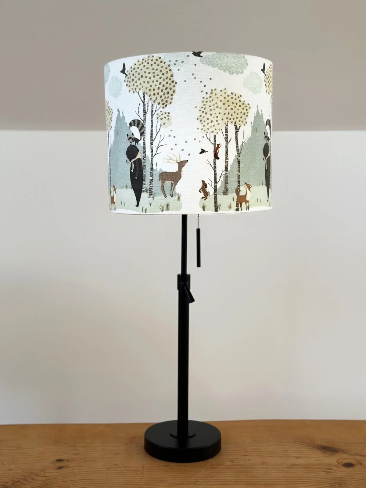 Children's Lamp with forest creatures on the shade and a black adjustable base.