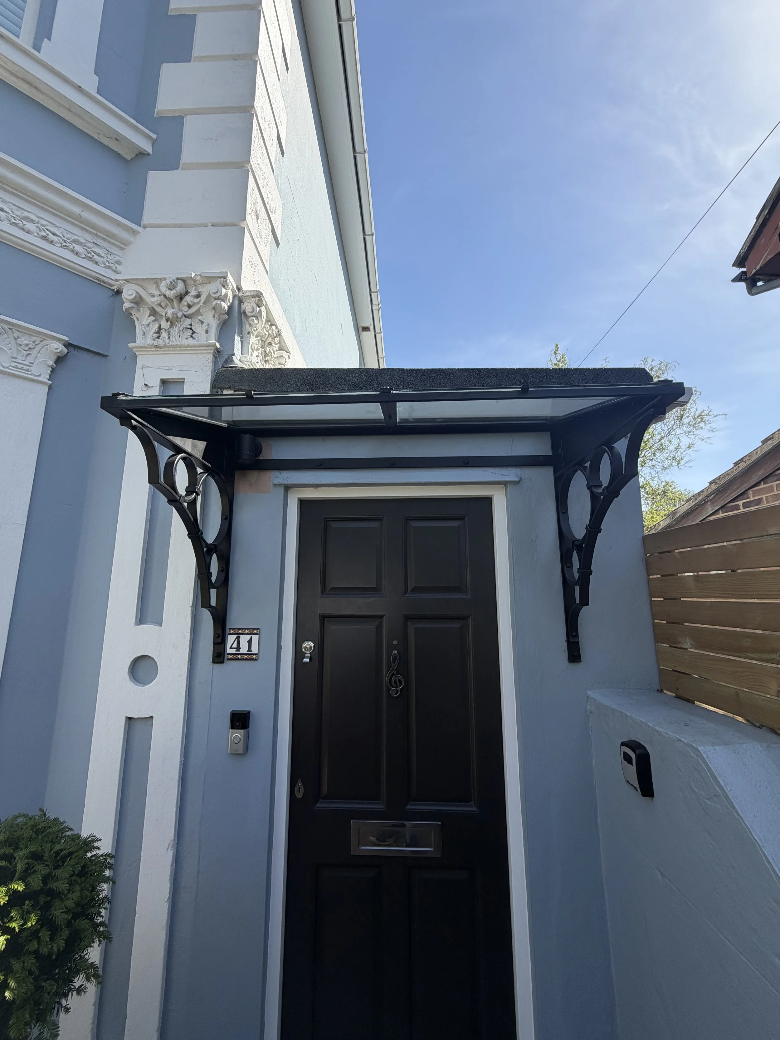 Bespoke Victorian-inspired steel and glass porch canopy installed on a period townhouse in Tunbridge Wells, Kent, with decorative forged steel brackets.