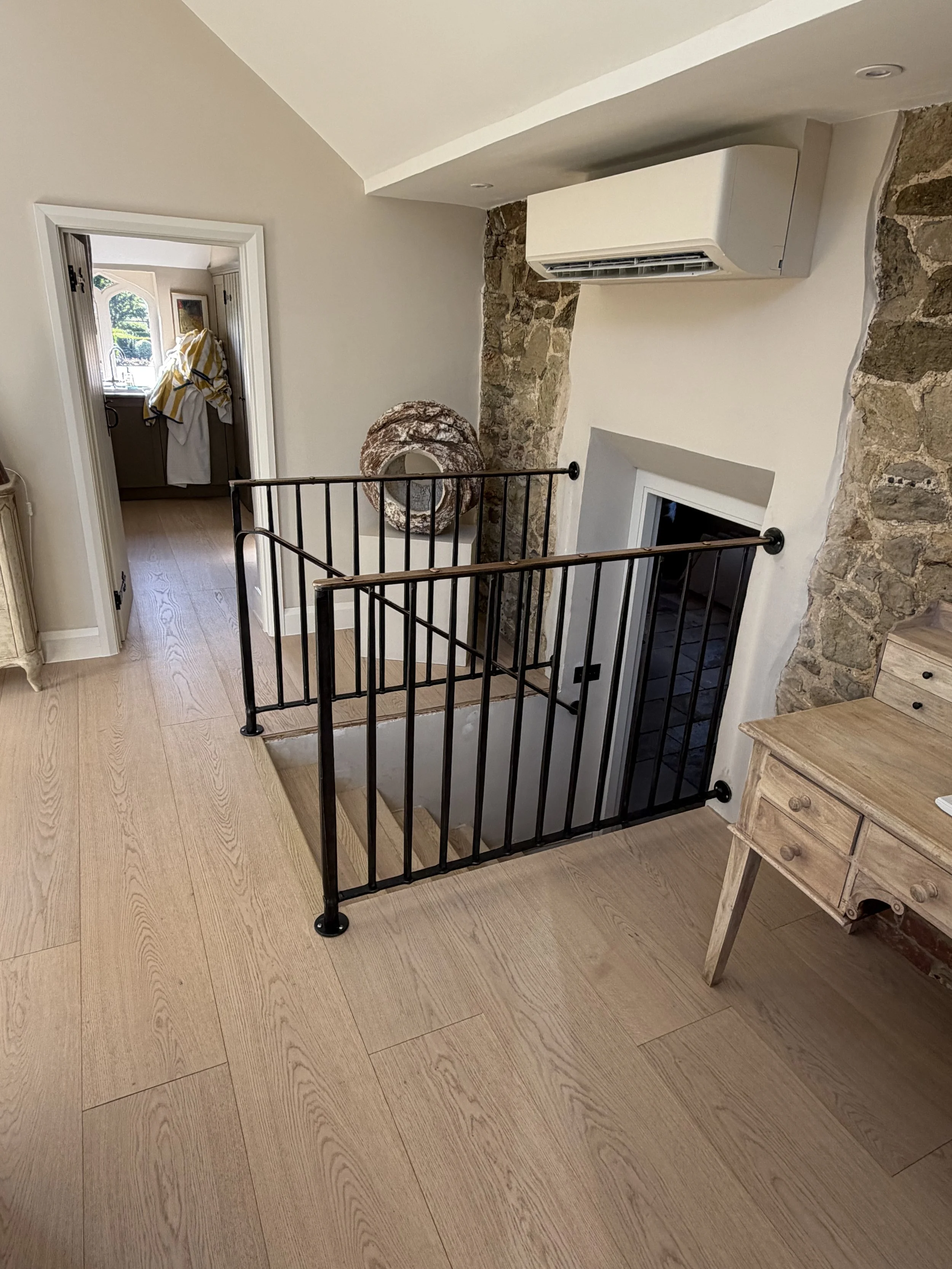 Finished bespoke forged steel balustrade with antiqued bronze handrail installed in a contemporary interior
