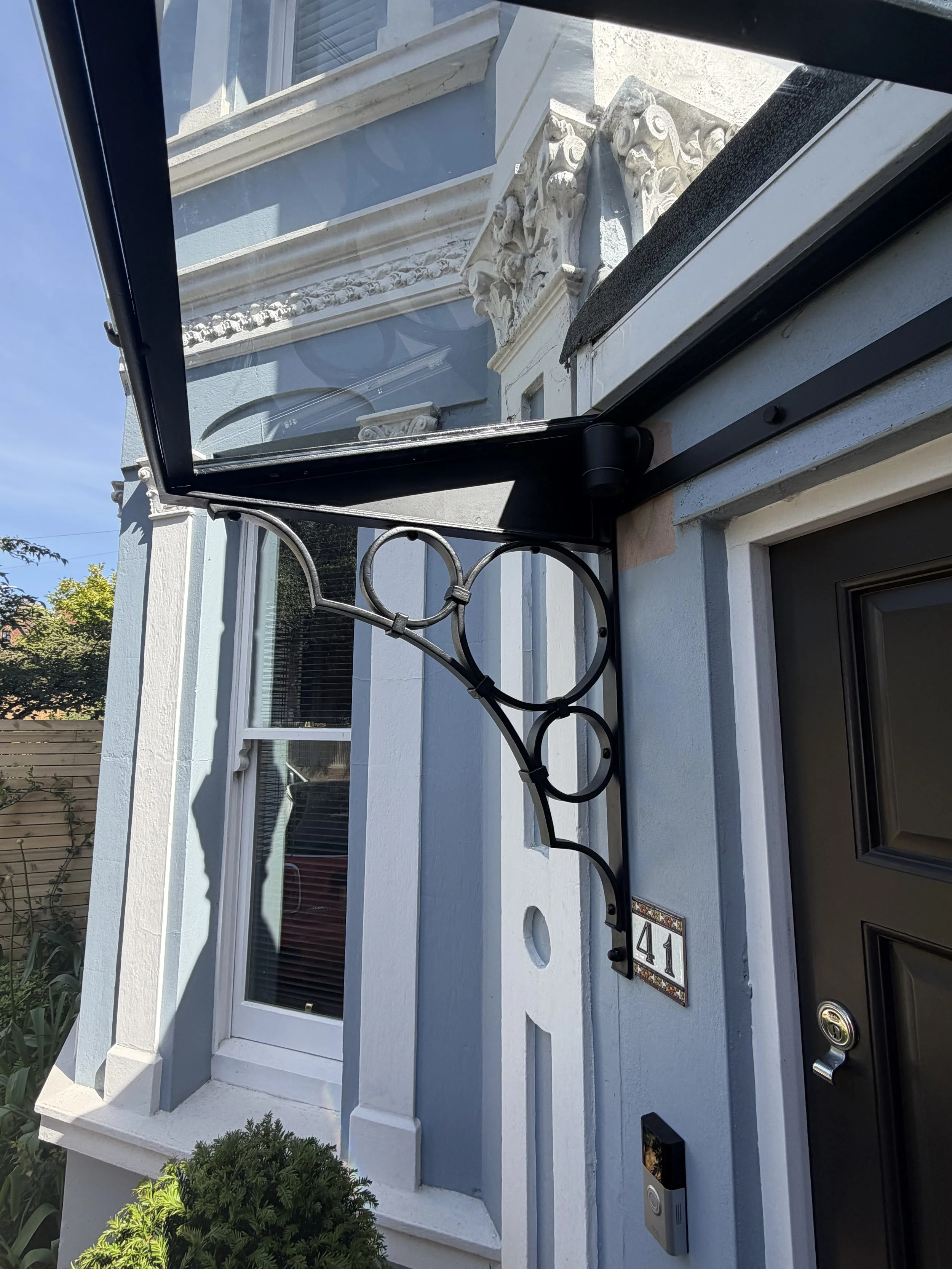 Bespoke Victorian-inspired steel and glass porch canopy installed on a period townhouse in Tunbridge Wells, Kent, with decorative forged steel brackets.