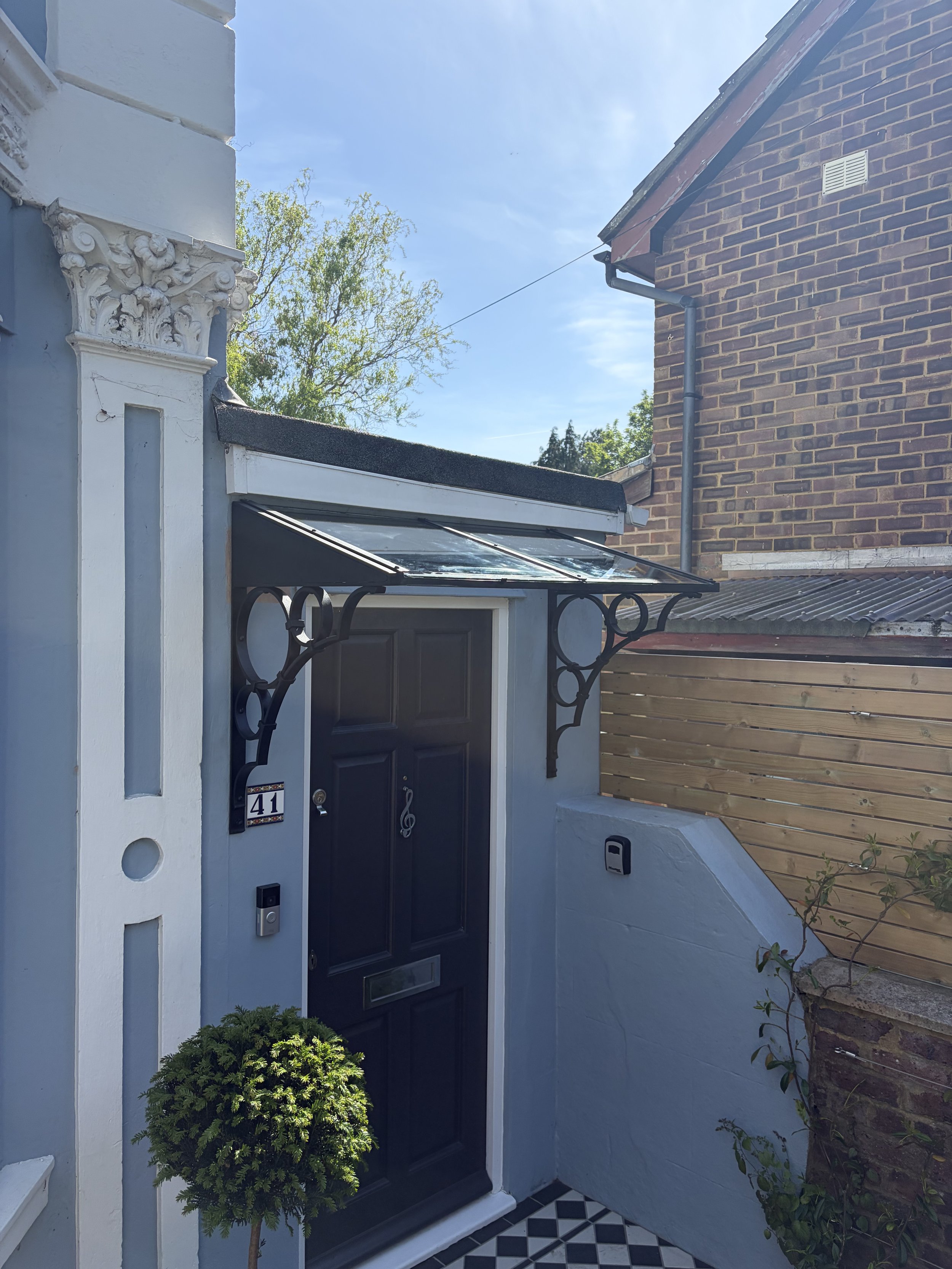 Bespoke Victorian-inspired steel and glass porch canopy installed on a period townhouse in Tunbridge Wells, Kent, with decorative forged steel brackets.
