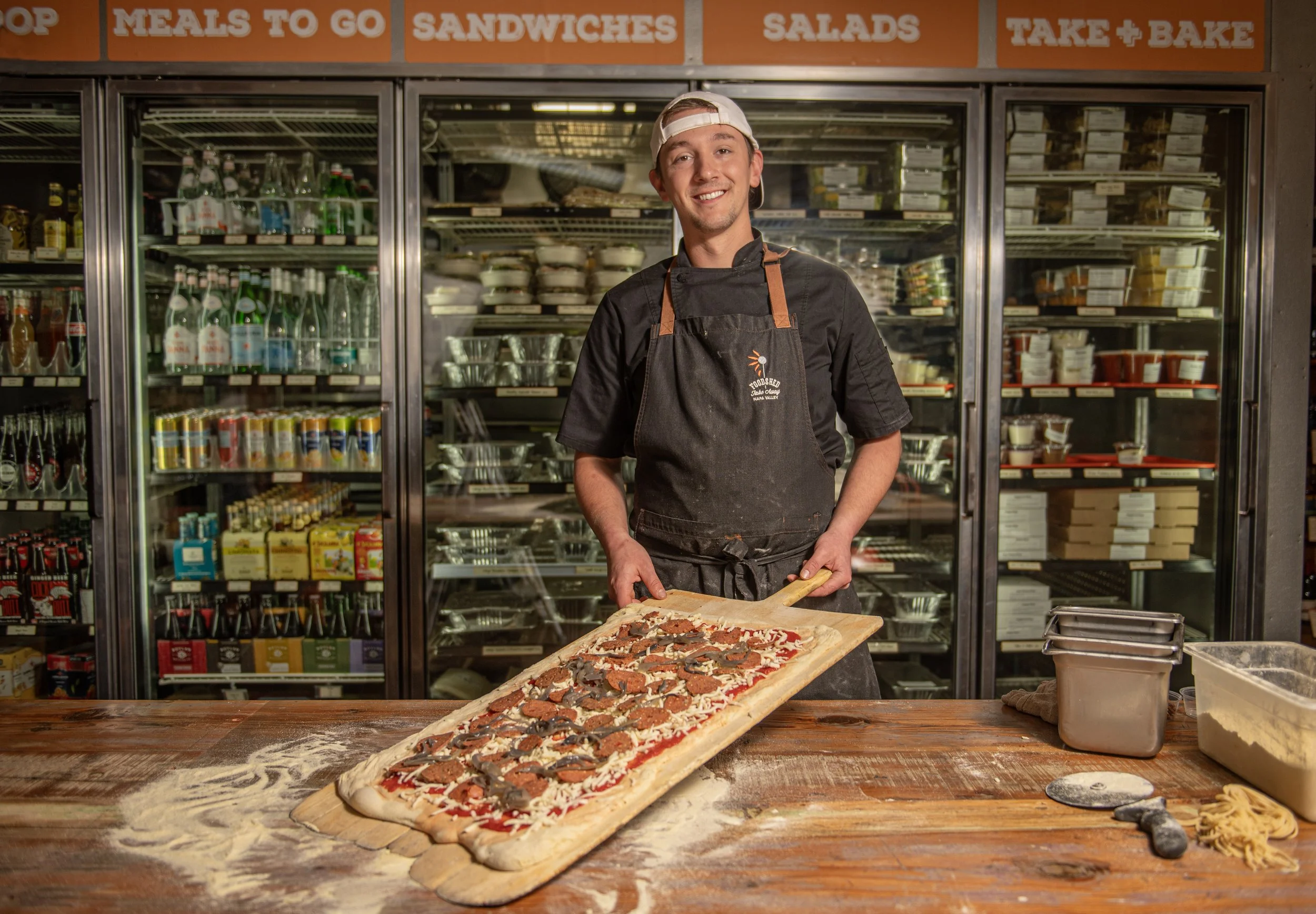 Chef singer holding a display of pepperoni pizza