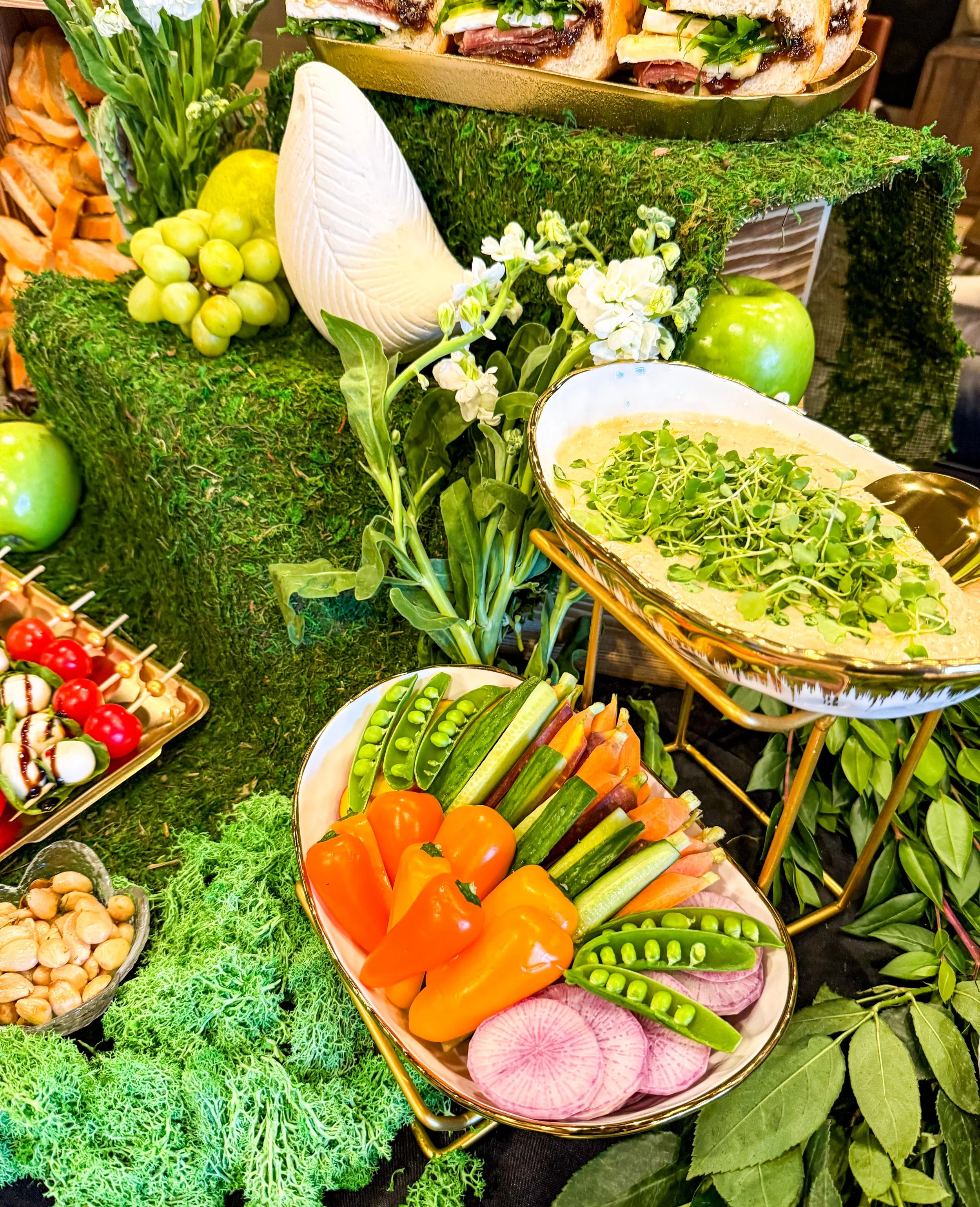 Grazing table with lots of greenery, fresh hummus and colorful crudite