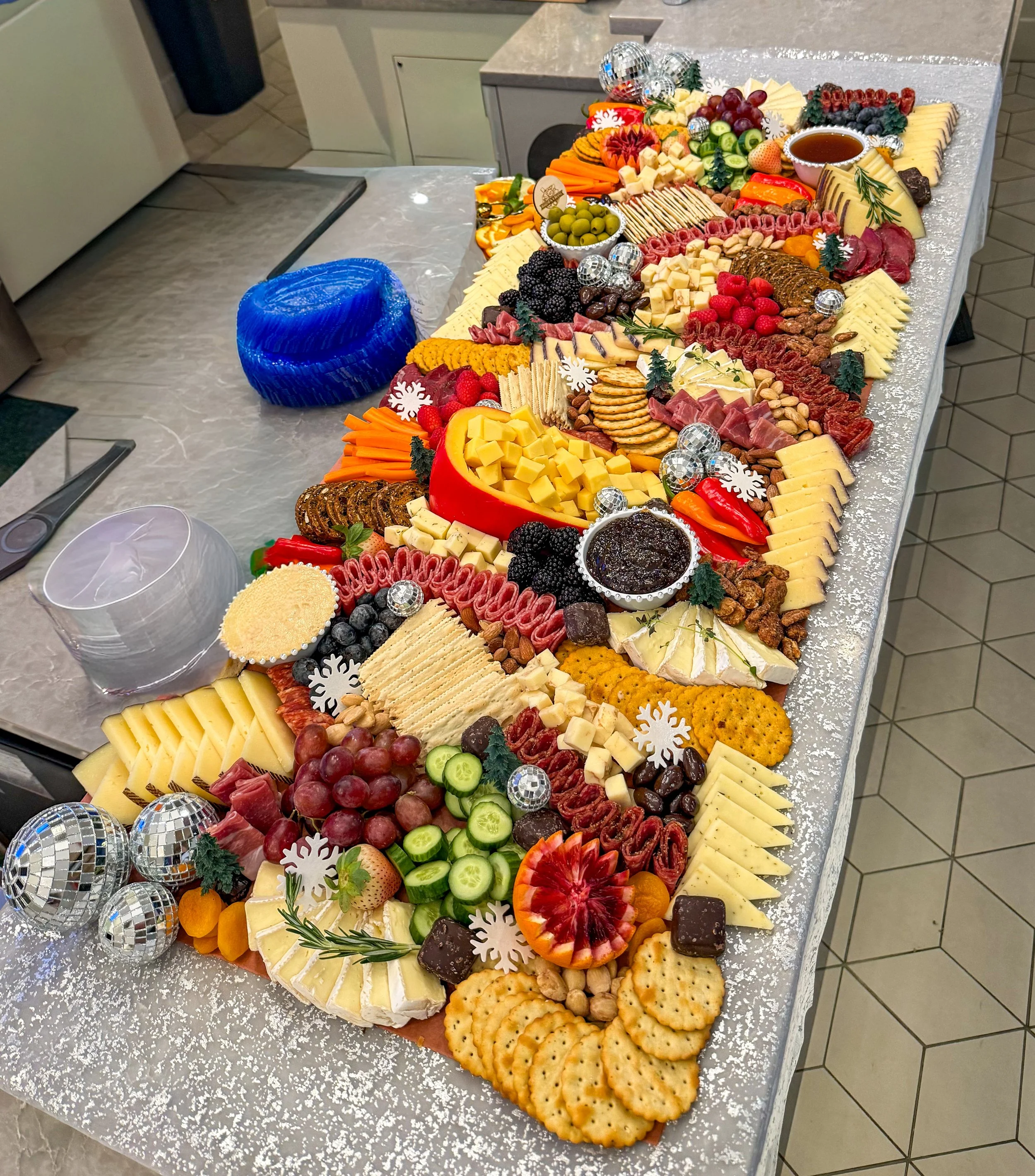 Apres ski grazing table with cheeses, meats, crackers, crudite, fresh fruit, jam, honey and disco balls