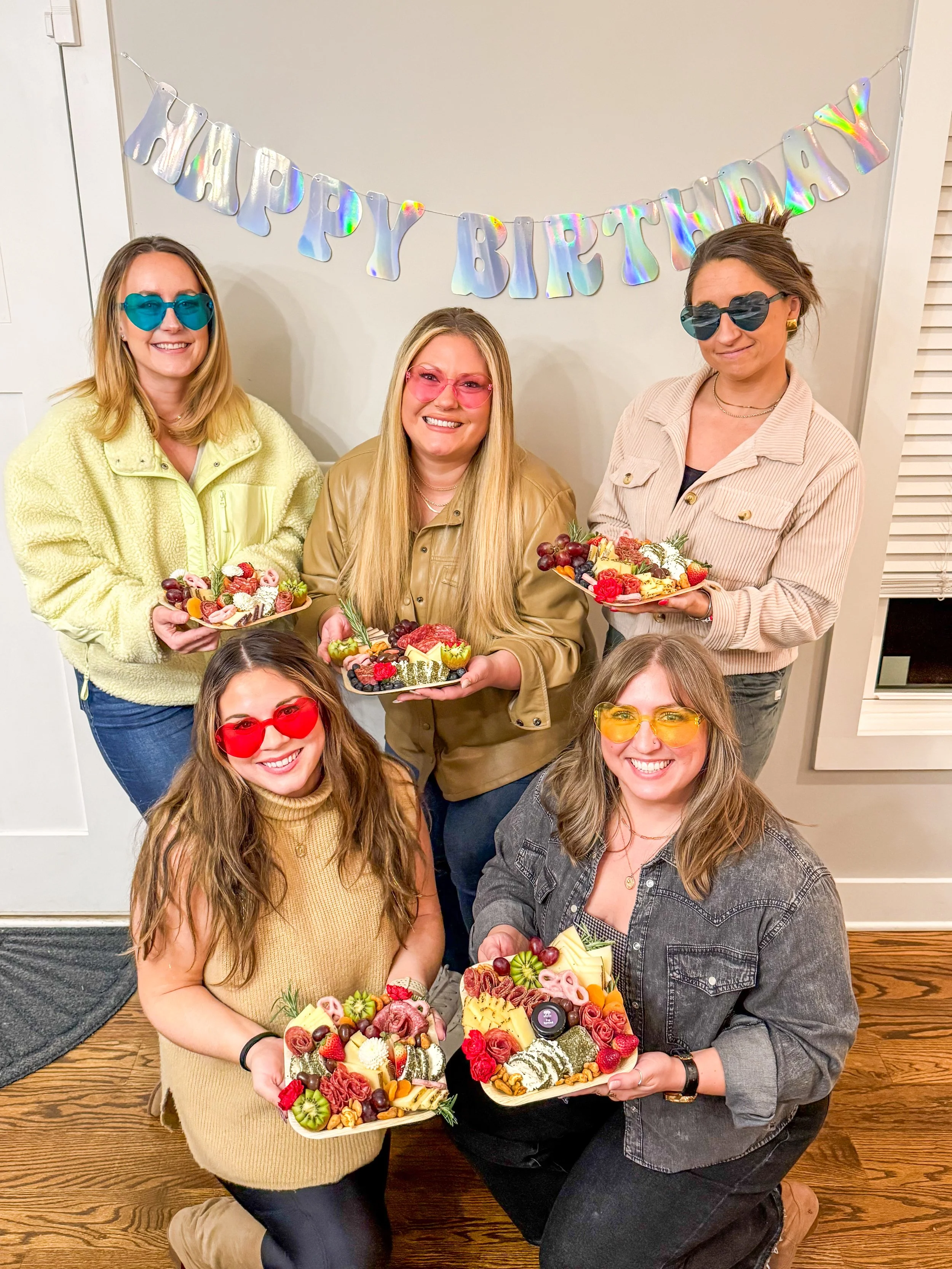 A group of five women celebrating a birthday in Nashville holding charcuterie boards they made during a workshop