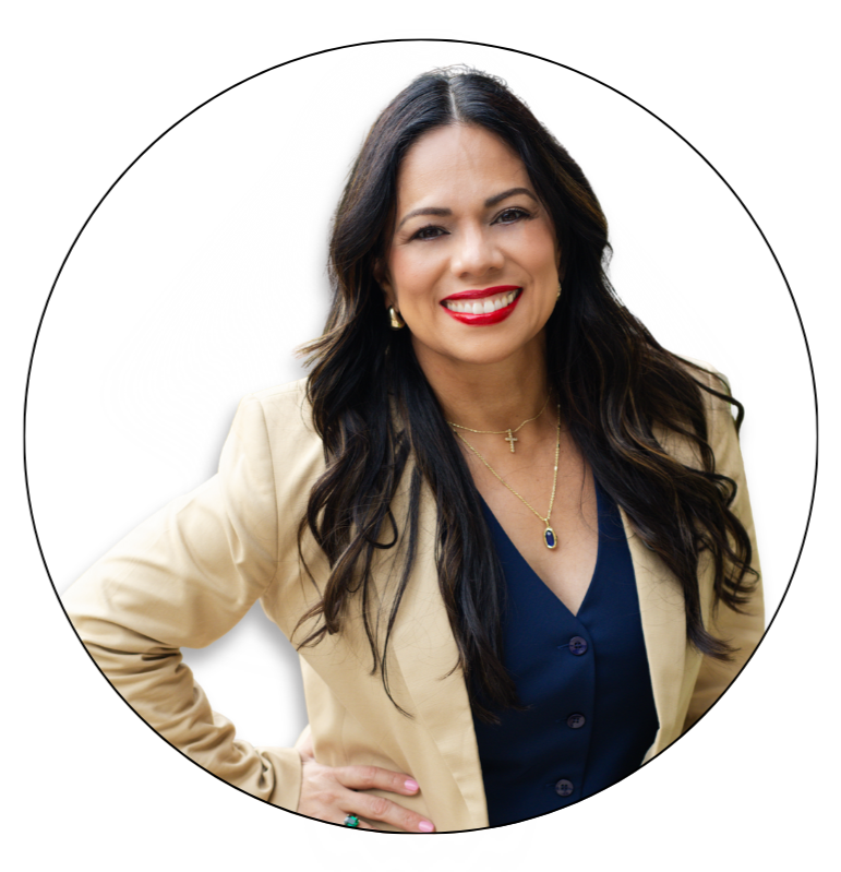 Esme Graff  with long dark hair, red lipstick, and a smile, wearing a beige blazer over a navy blouse, accessorized with necklaces and earrings, posing against a white background.