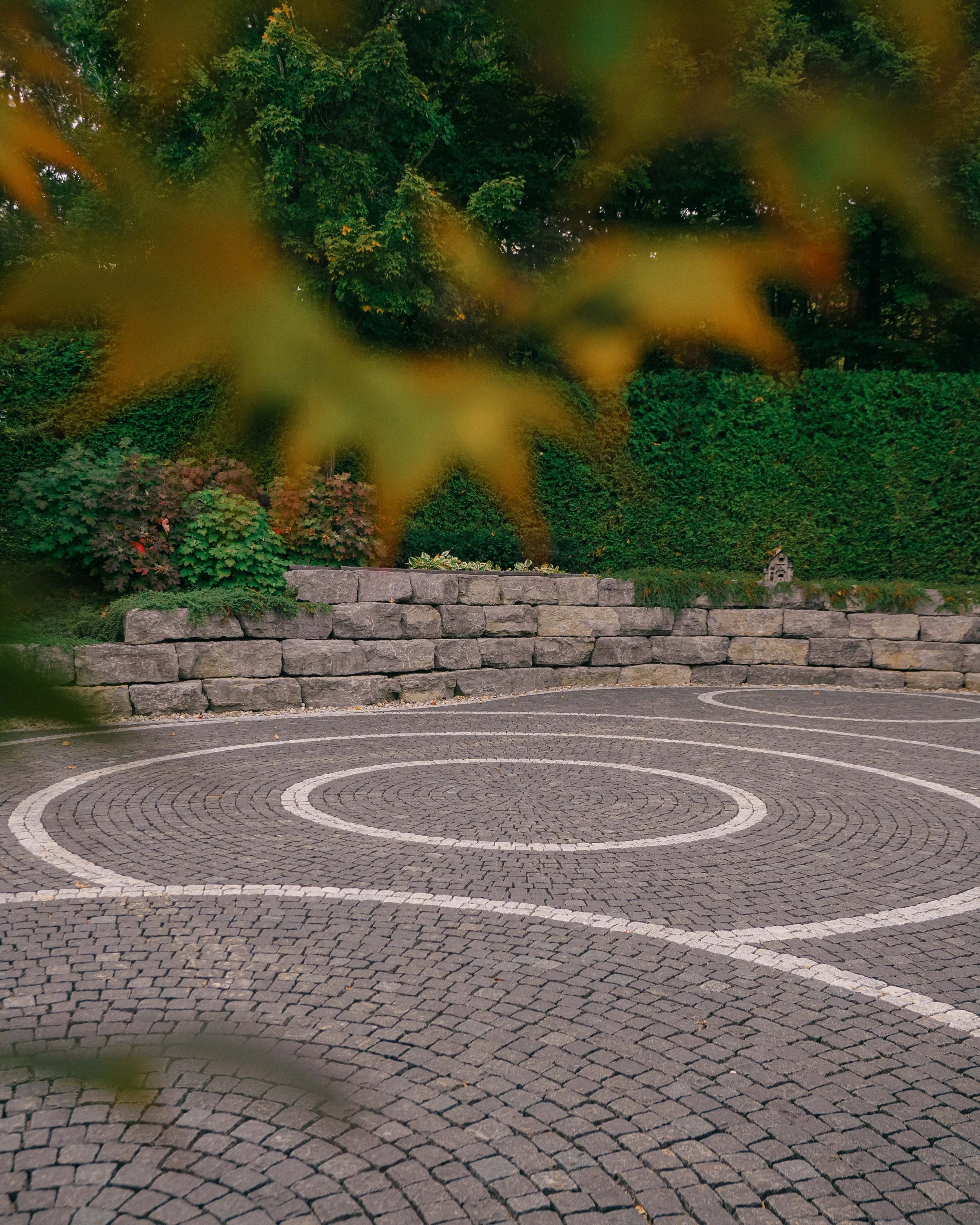 Cobblestone pavers with a natural armour stone wall.
