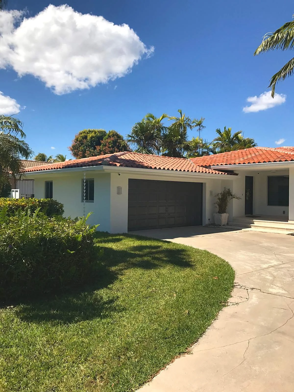 White seamless gutters on a terracotta tile roof at a single-story Miami home