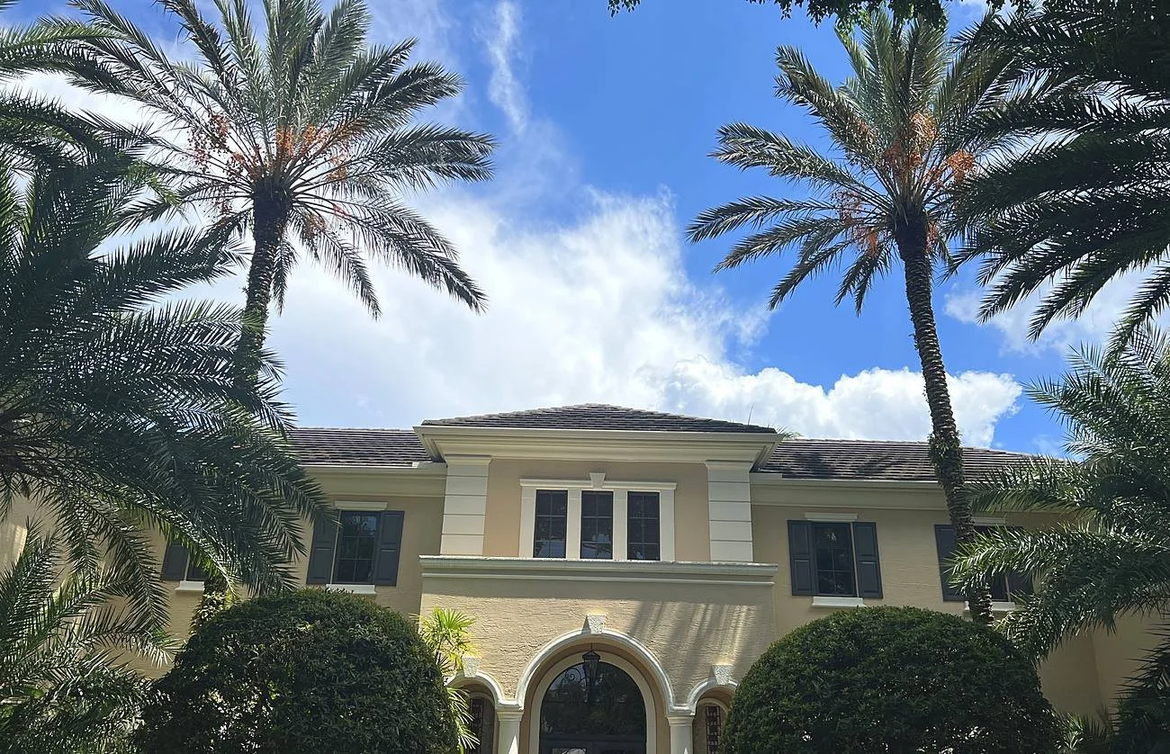 Mediterranean estate in Coral Gables with a tile roof and cream seamless gutters matched to the trim