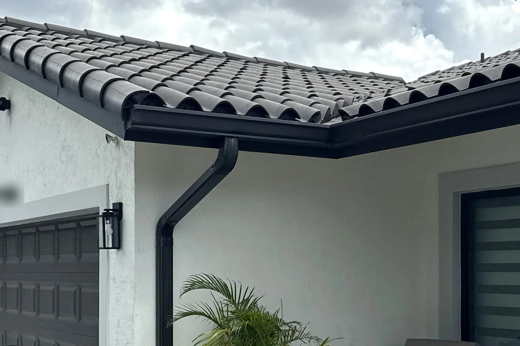The same gutter after cleaning, clear and draining freely into the downspout