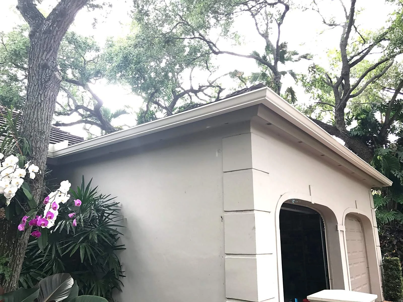 Close-up of a 6-inch seamless aluminum gutter in Linen along the garage fascia of a Coral Gables home