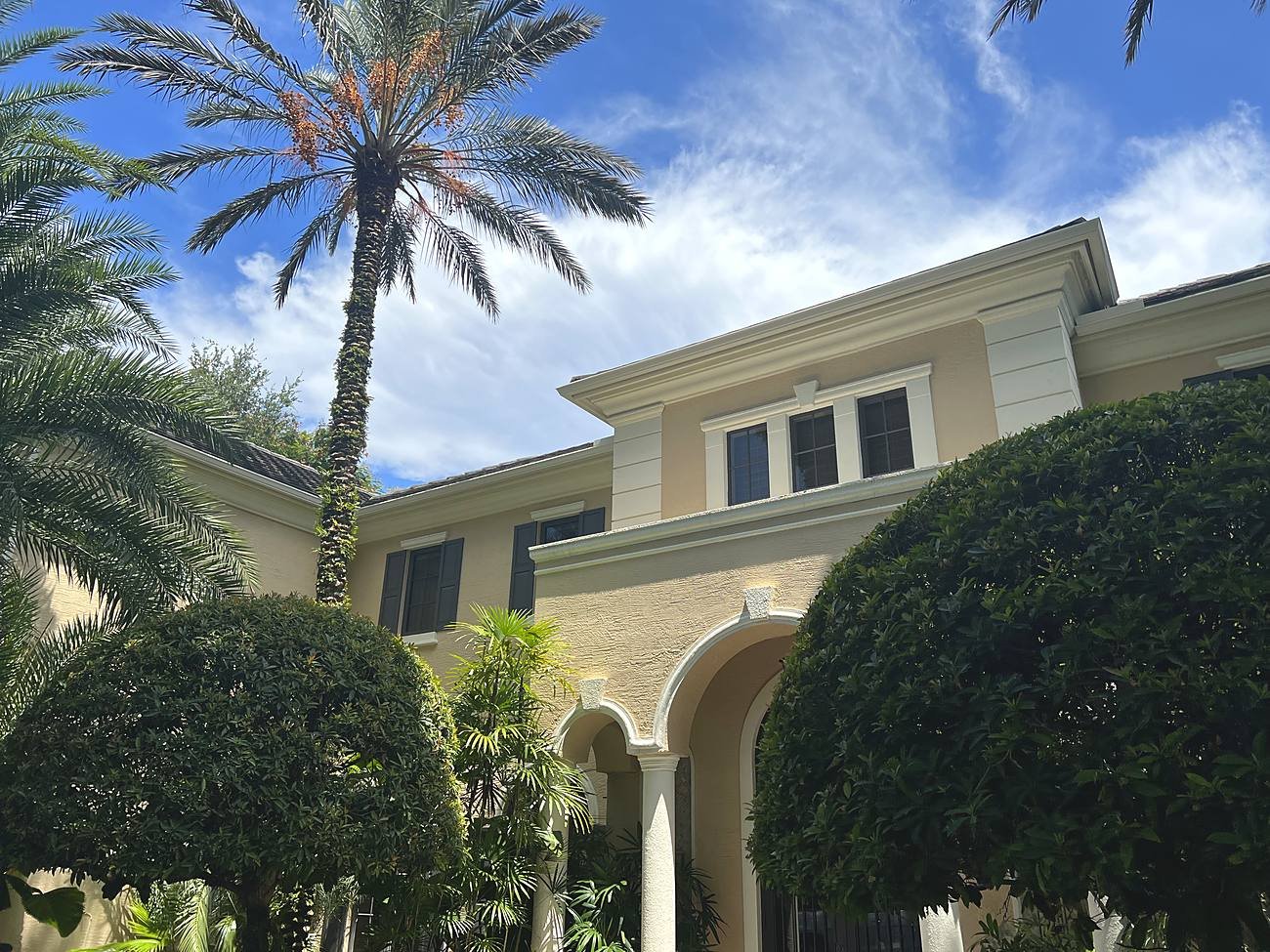 Close-up of a cream seamless aluminum gutter along the cornice of a Coral Gables tile-roof home