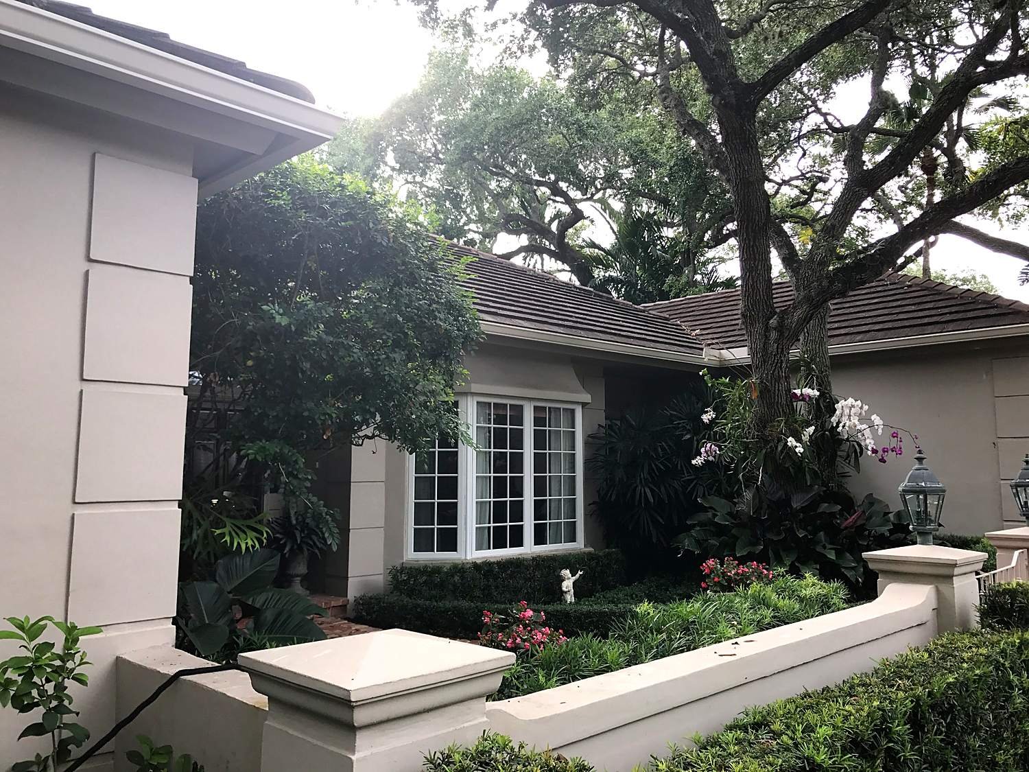 Linen seamless gutter and return along a Coral Gables home with tile roof and dense tropical landscaping