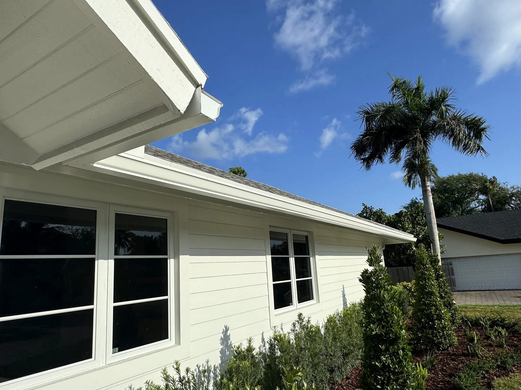 White seamless aluminum gutters along the roofline of a Kendall, FL home