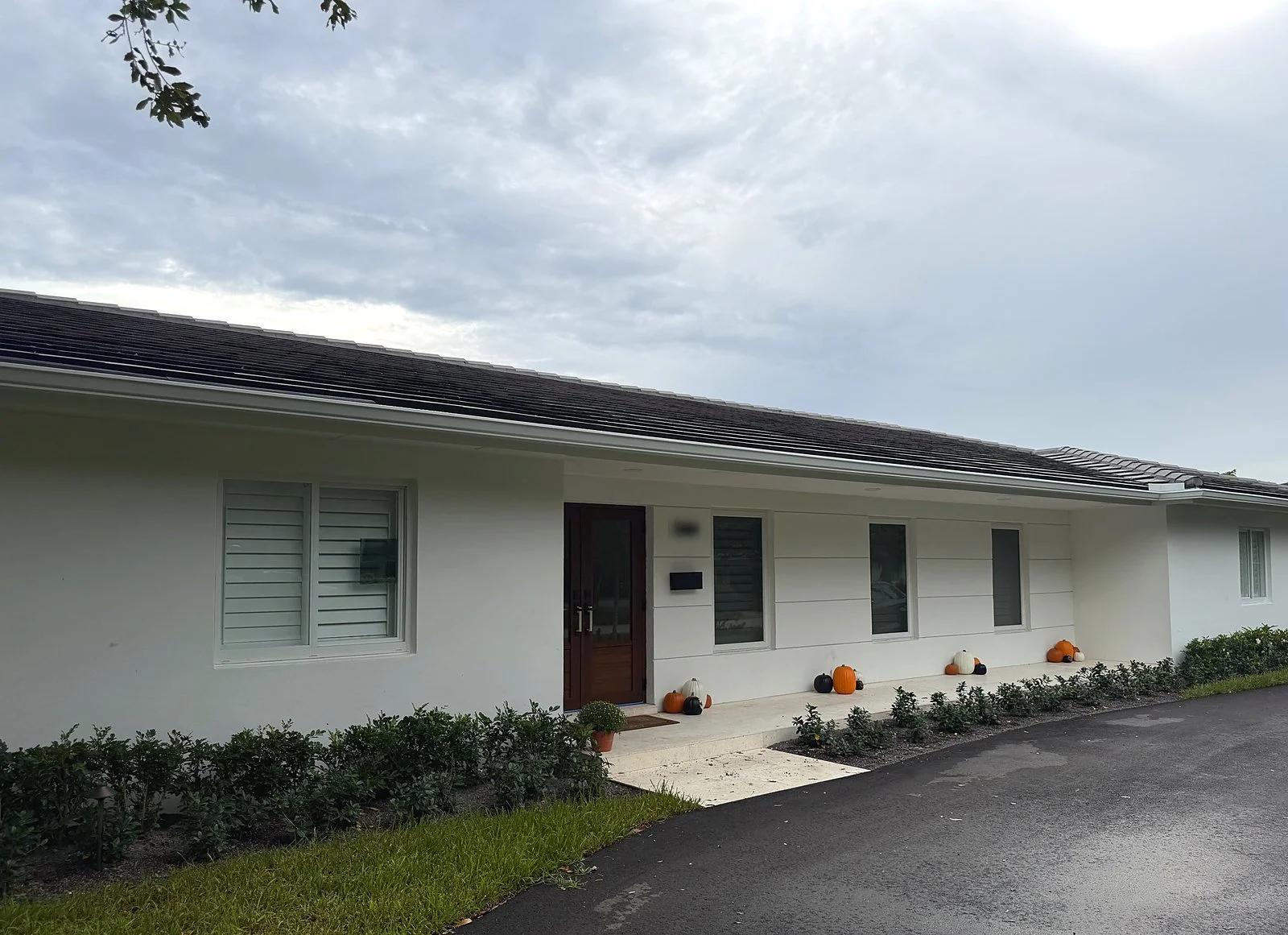 White seamless gutter running the full length of a mid-century ranch home with a tile roof