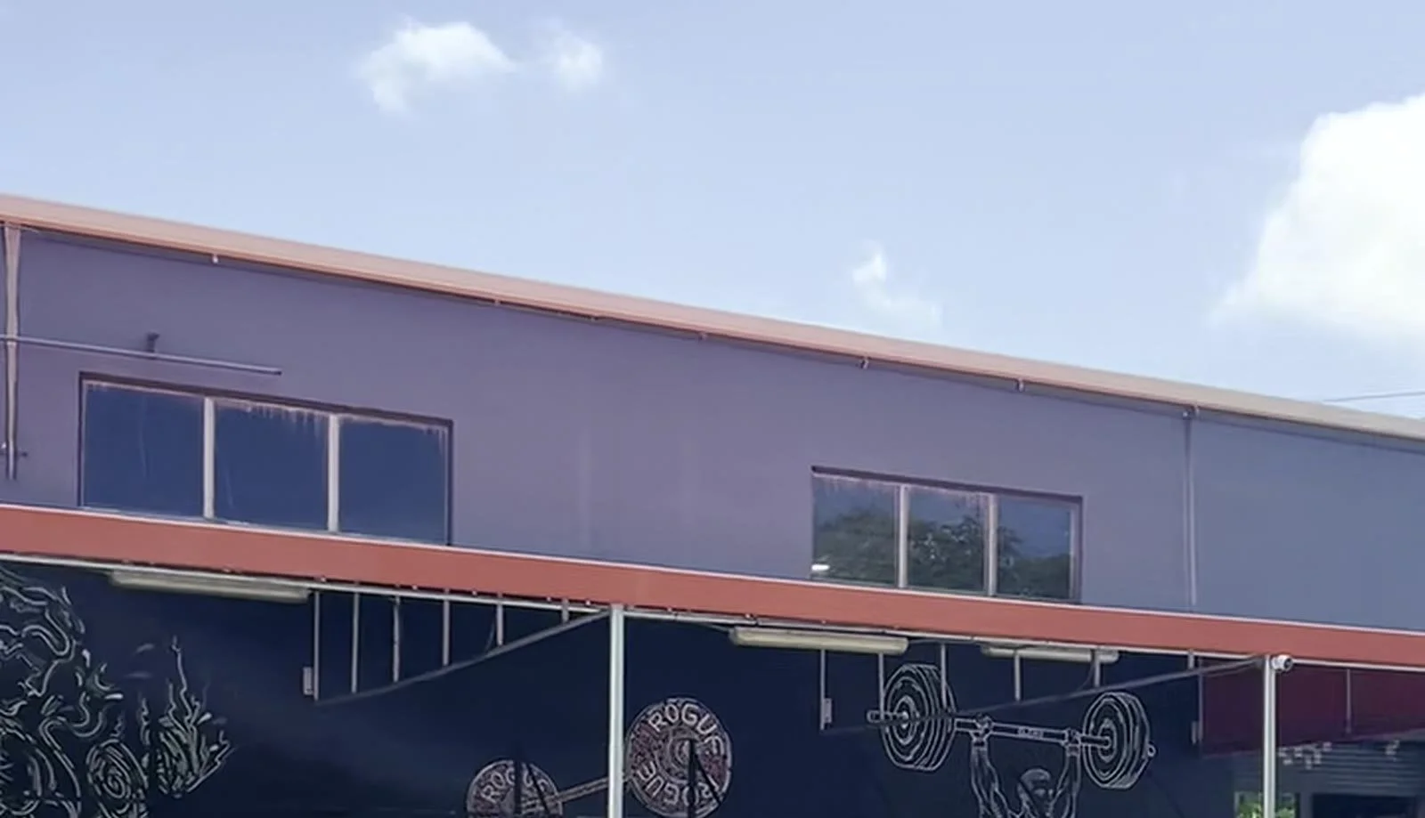 Commercial downspout running the full height of a warehouse wall in Miami