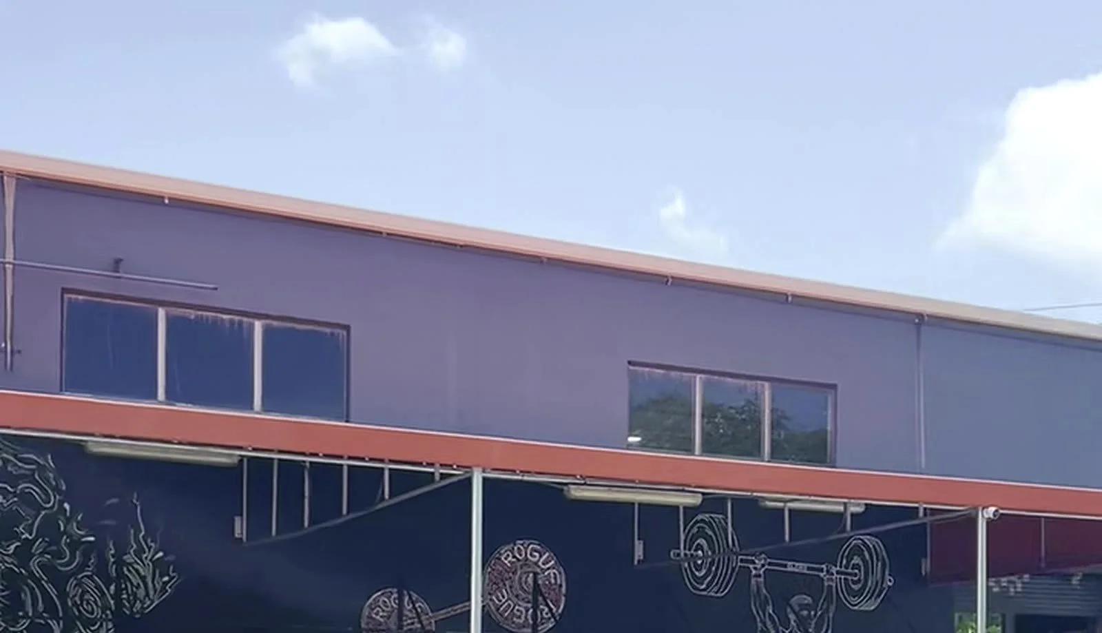 Long seamless gutter run along the roofline of a commercial warehouse building